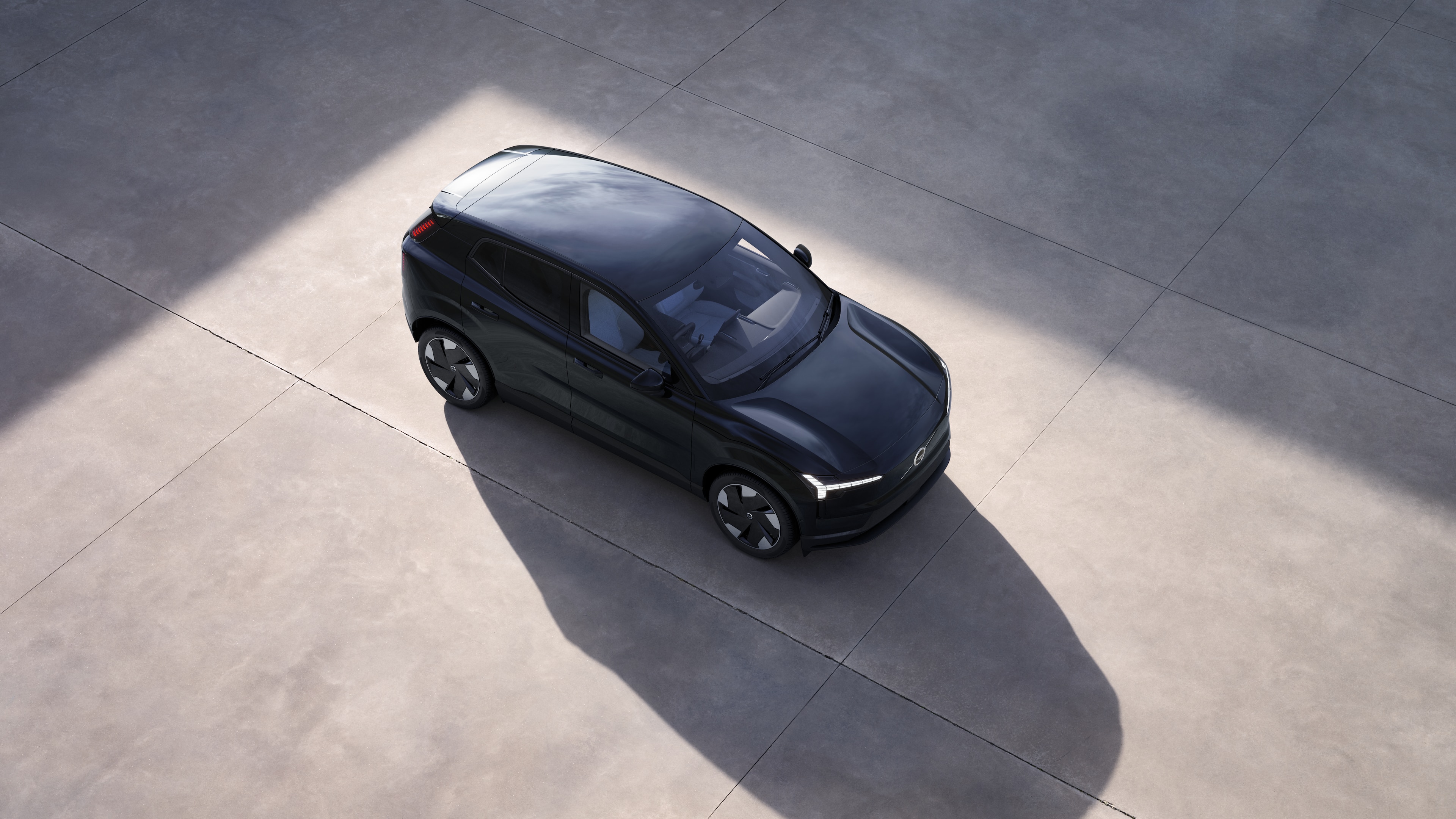 無地のスタジオ背景に上から見たボルボ車のエクステリア。