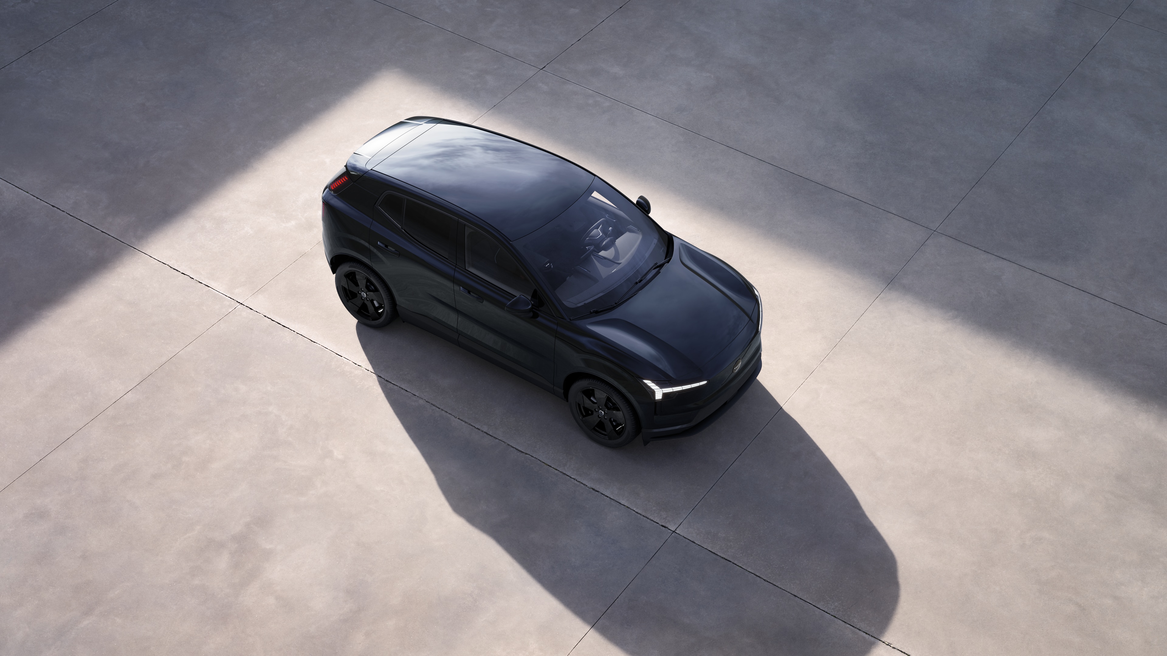 Das Äussere eines Volvo Fahrzeugs wird von oben im schlichten Studiohintergrund gezeigt.