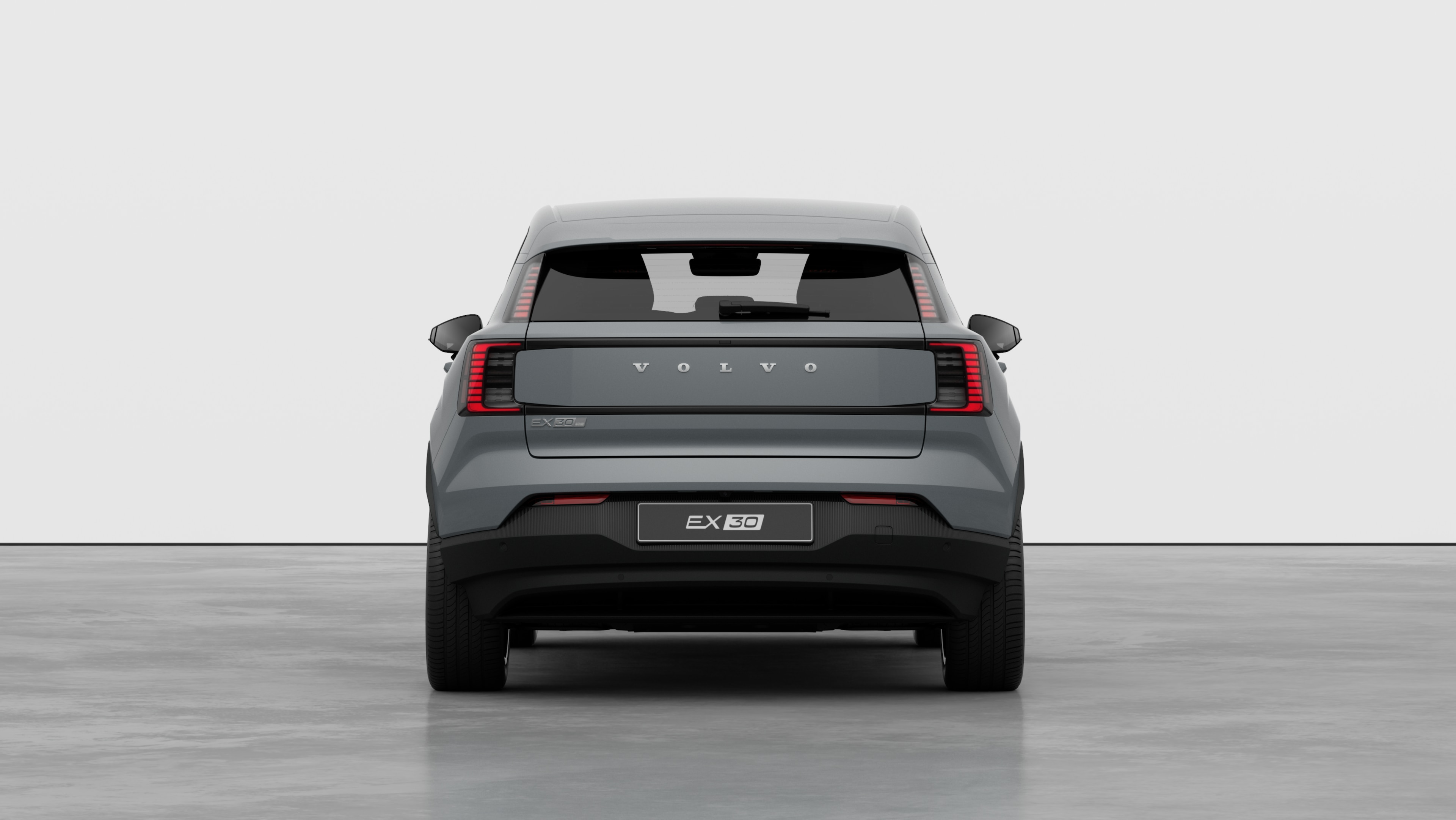 Vue arrière d’une voiture Volvo sur un fond de studio uni.