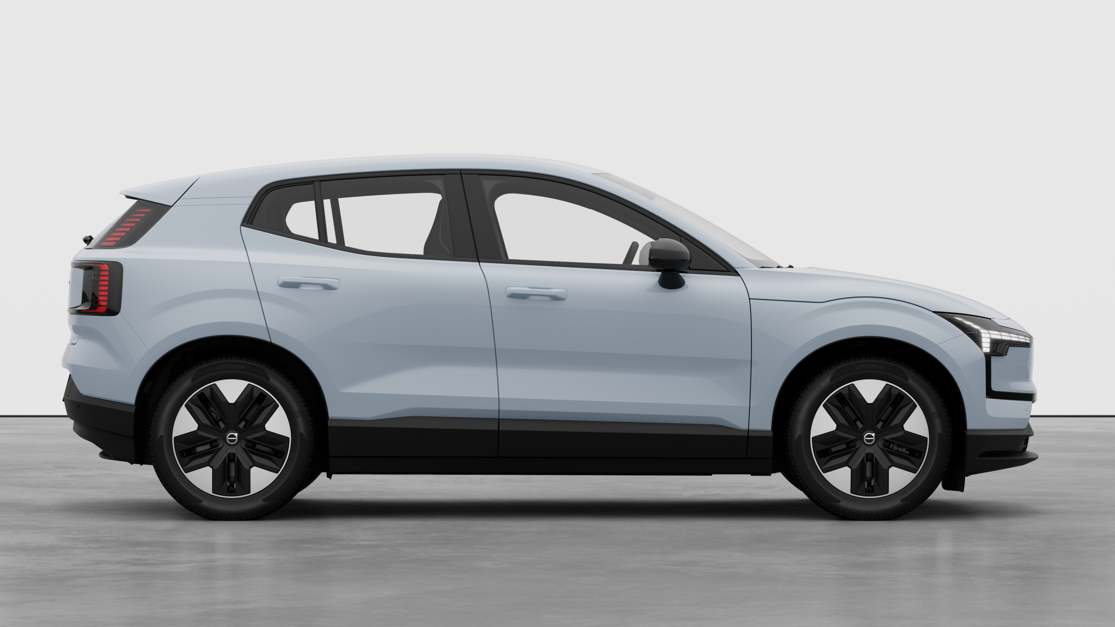 Vue latérale d’une Volvo sur un fond de studio uni, montrant les portes fermées et le design des roues visibles.