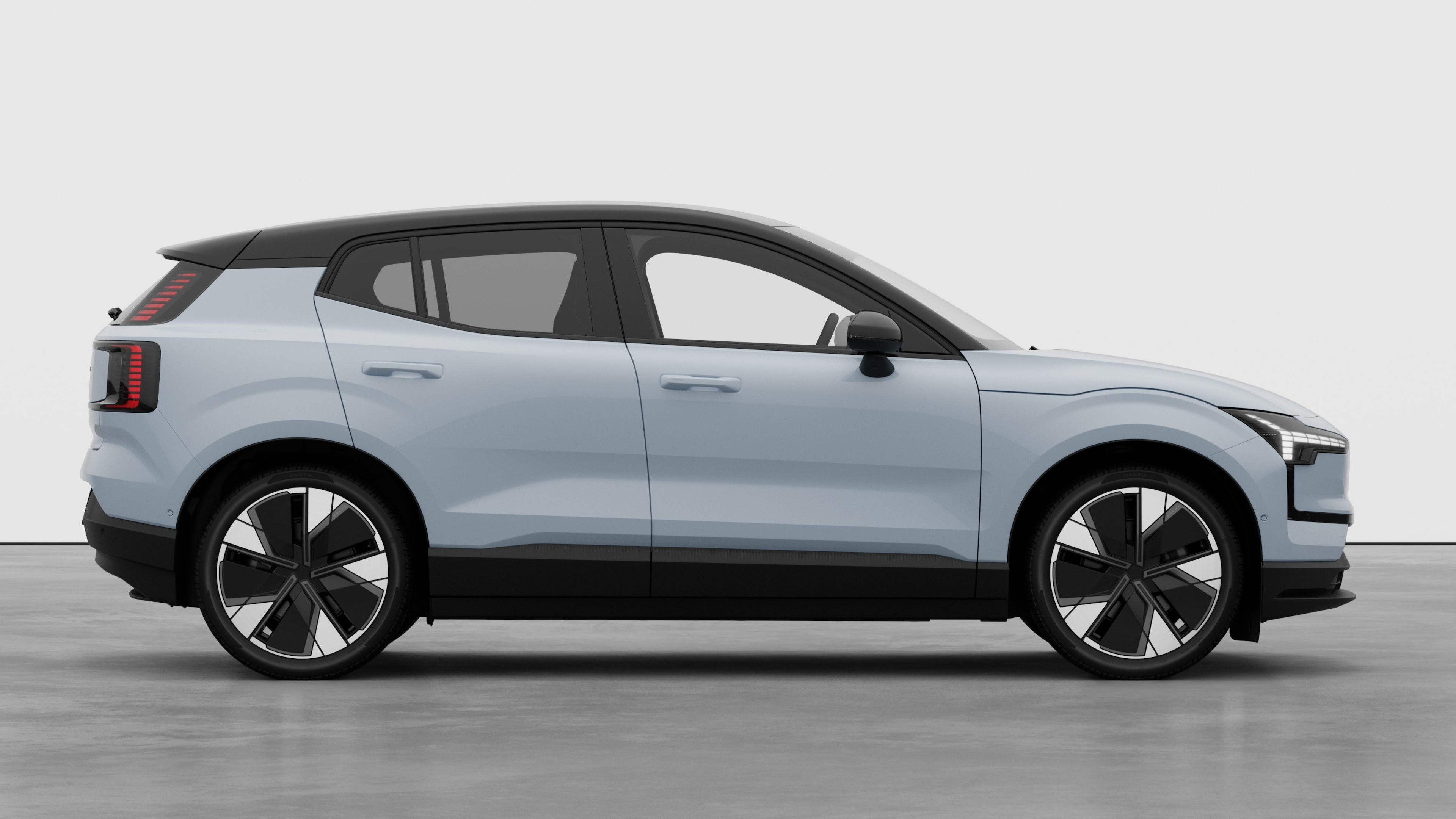 Volvo car side view on plain studio background displaying closed doors and visible wheel design.