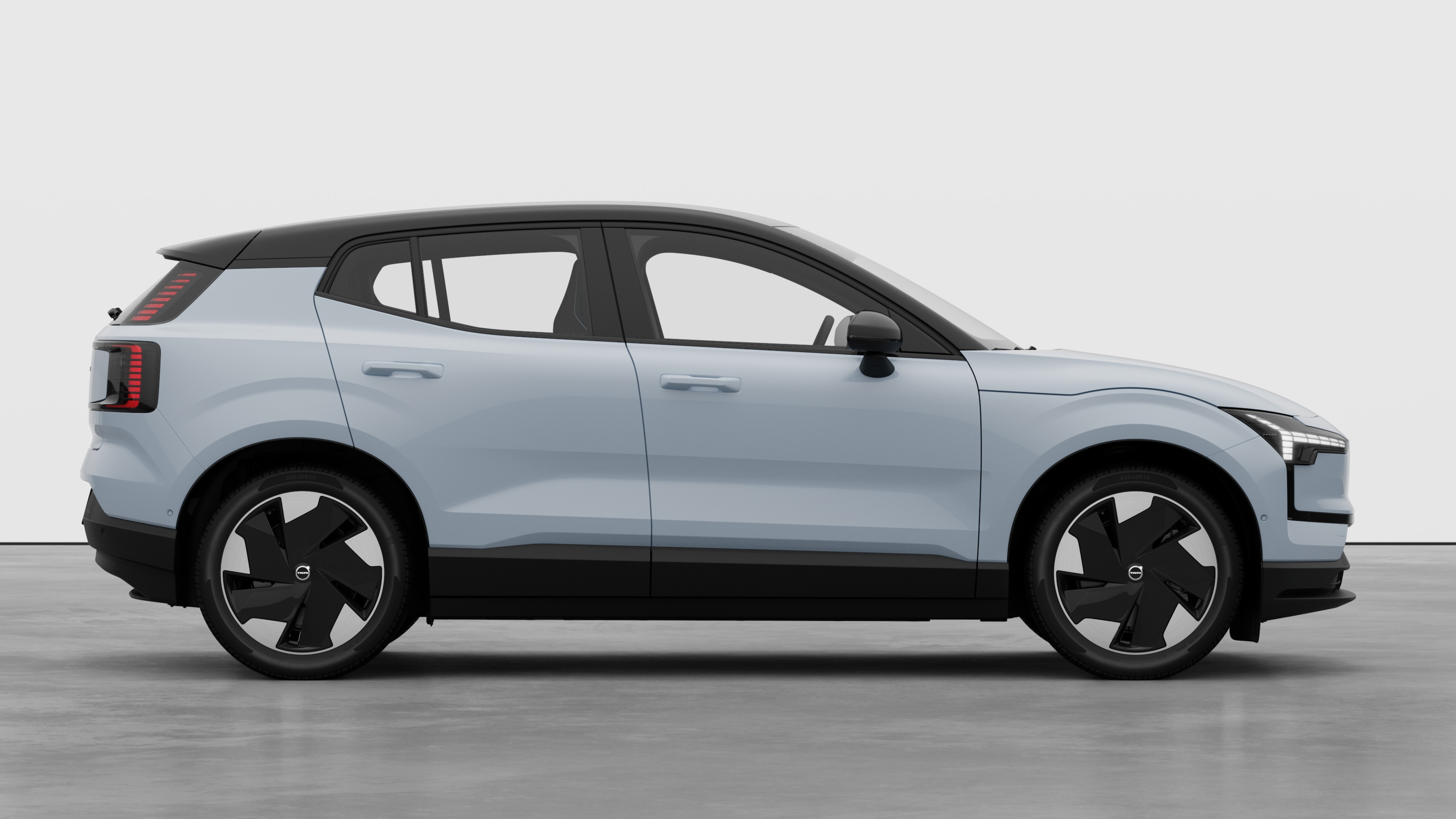 Seitenansicht eines Volvo Fahrzeugs auf einem schlichten Studiohintergrund mit geschlossenen Türen und sichtbarem Raddesign.