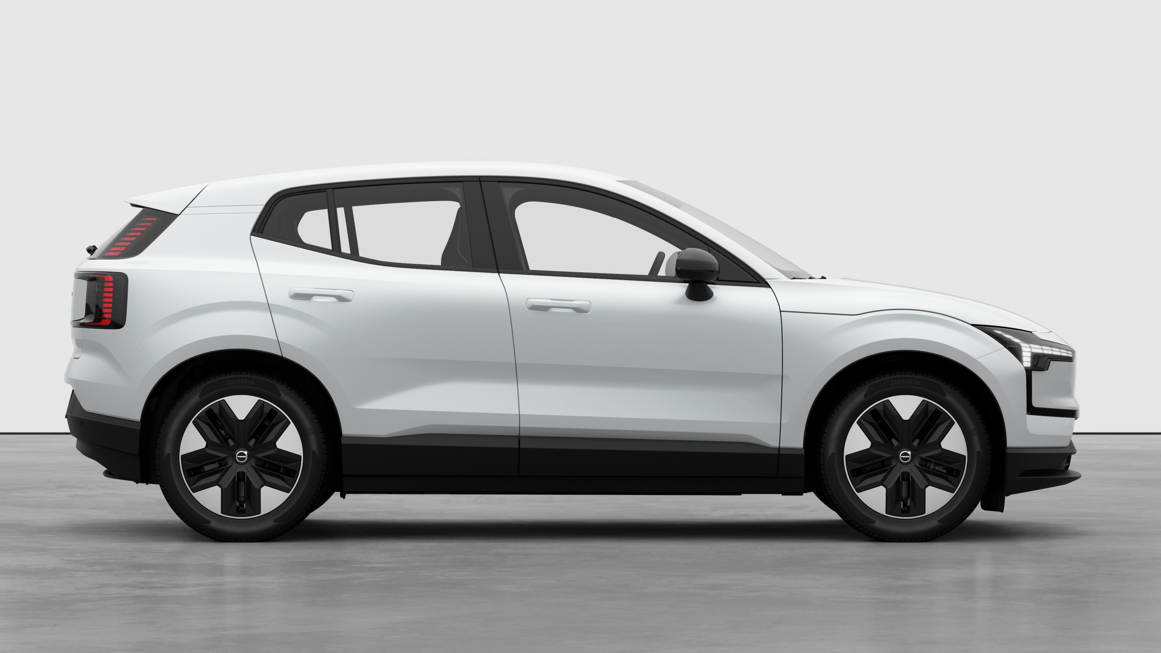 Vista laterale di un'auto Volvo sullo sfondo di uno studio che mostra le portiere chiuse e il design visibile delle ruote.