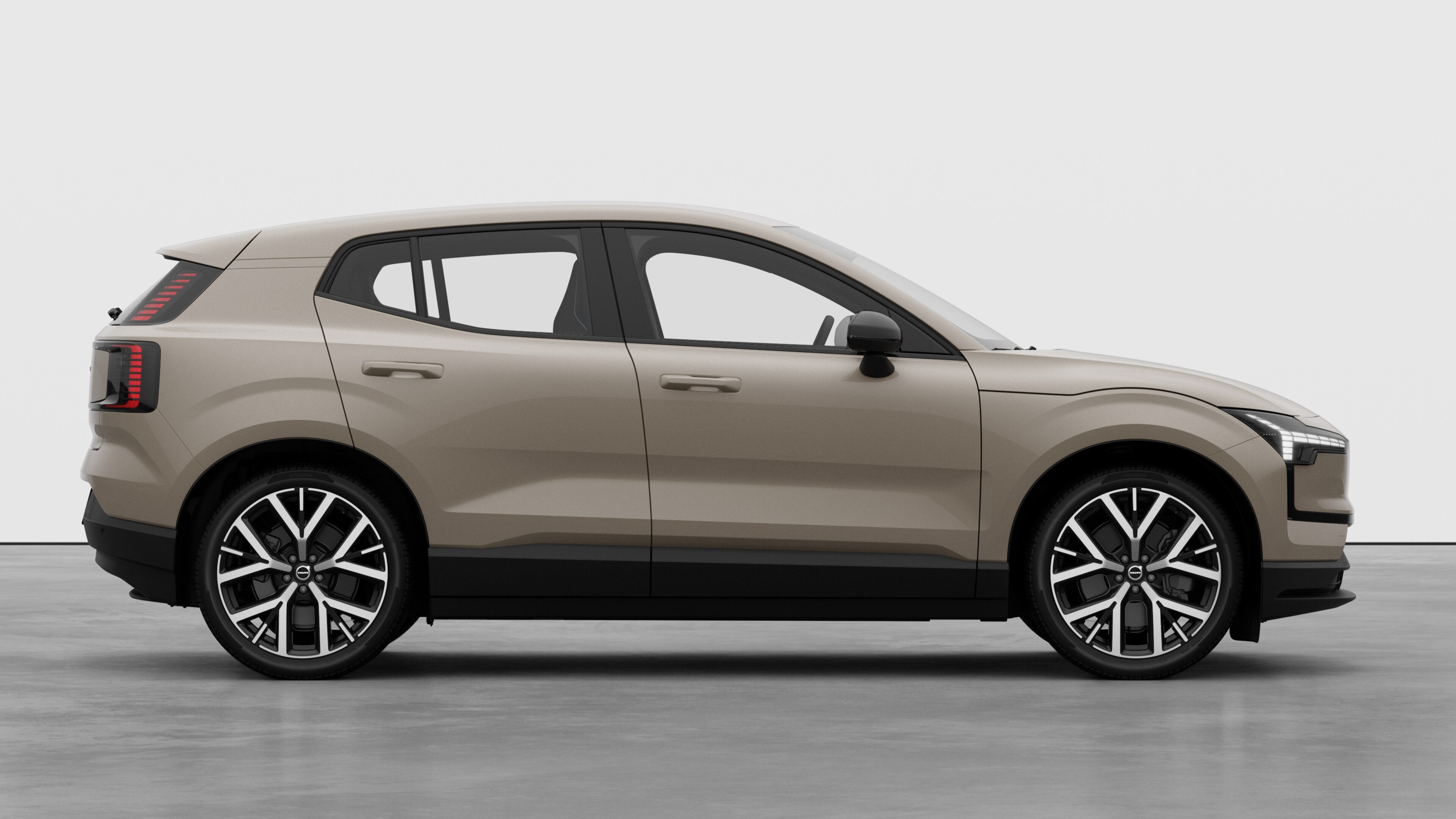 Volvo car side view on plain studio background displaying closed doors and visible wheel design.