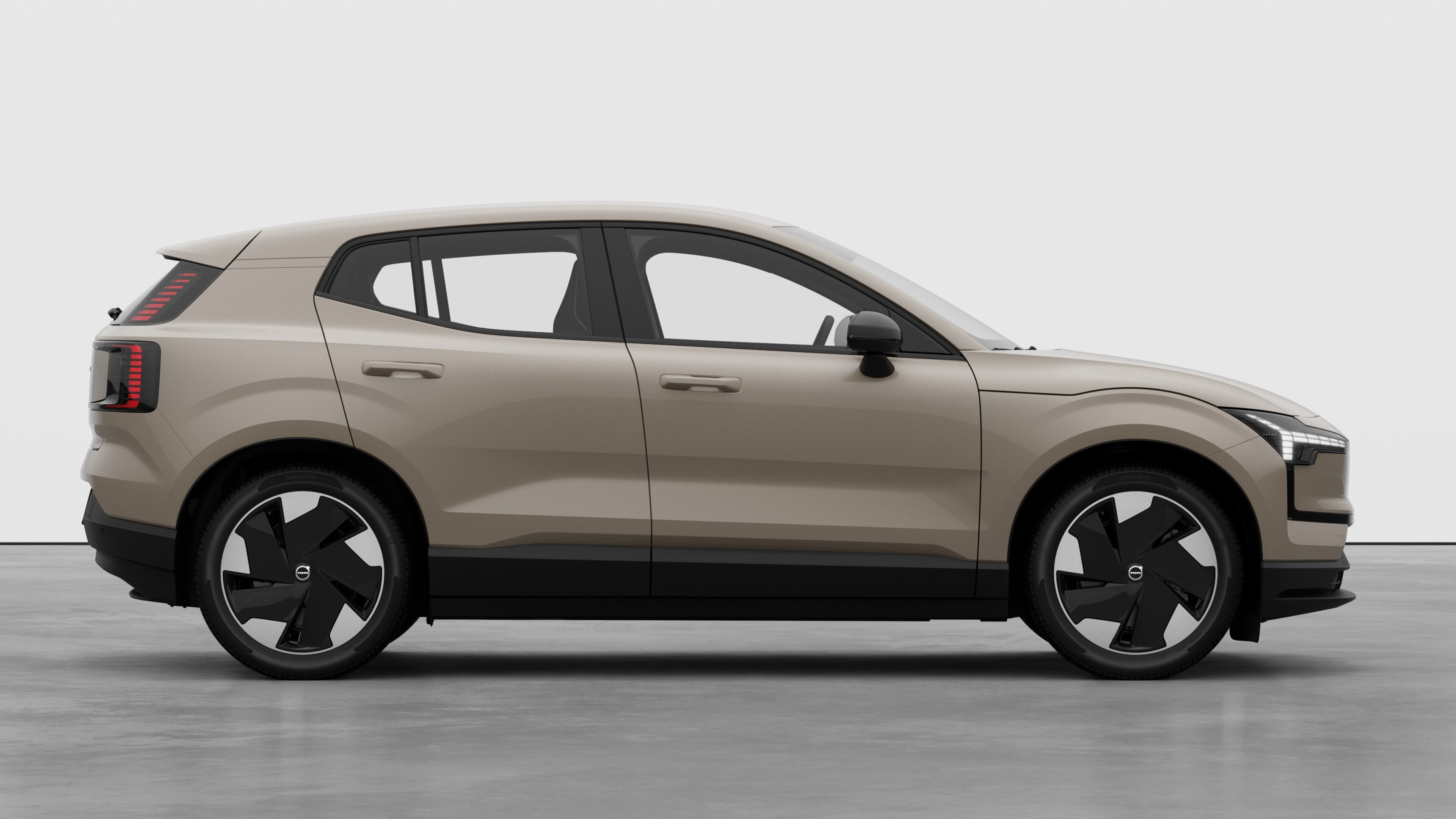 Volvo car side view on plain studio background displaying closed doors and visible wheel design.