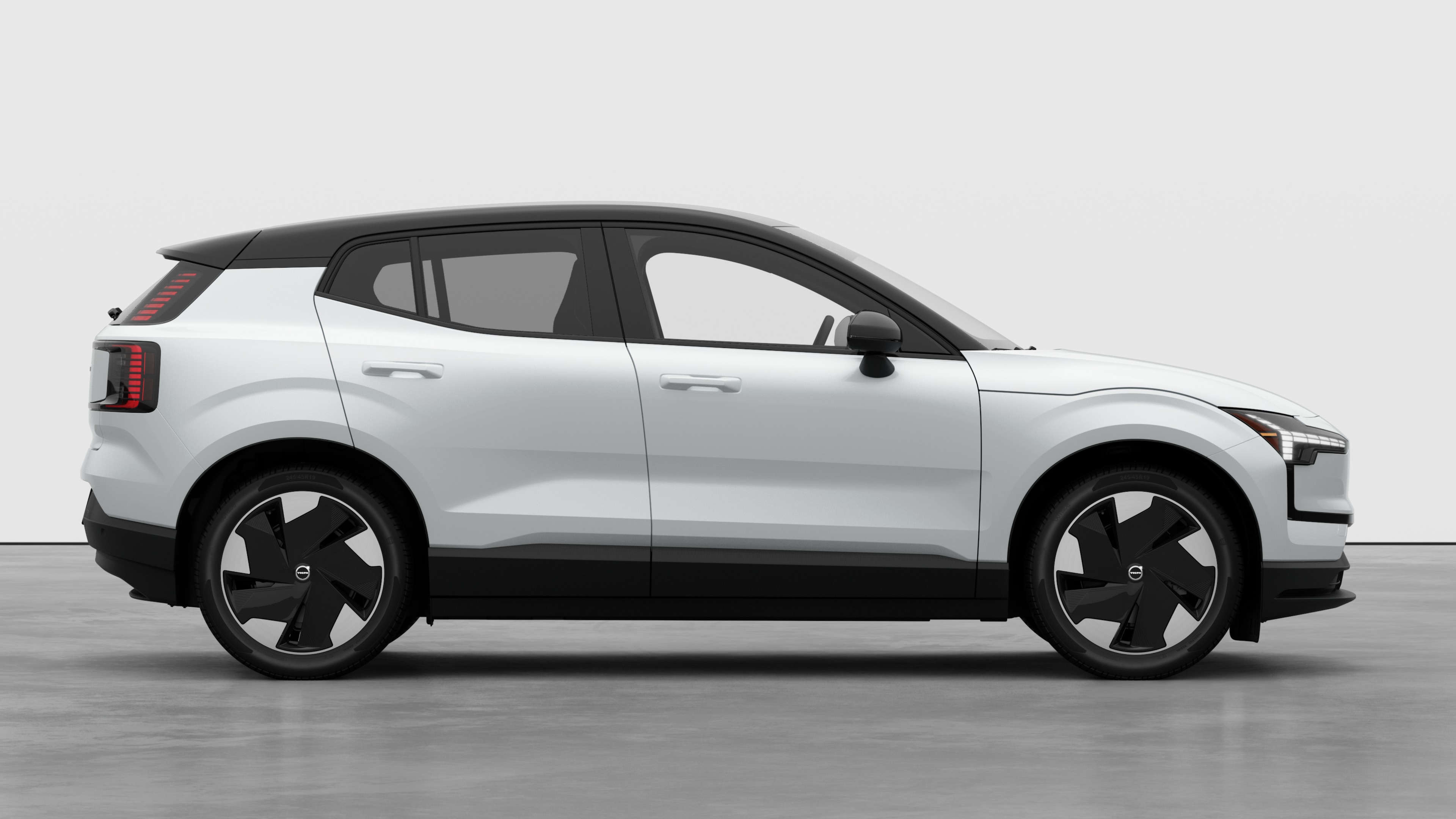 Volvo car side view on plain studio background displaying closed doors and visible wheel design.