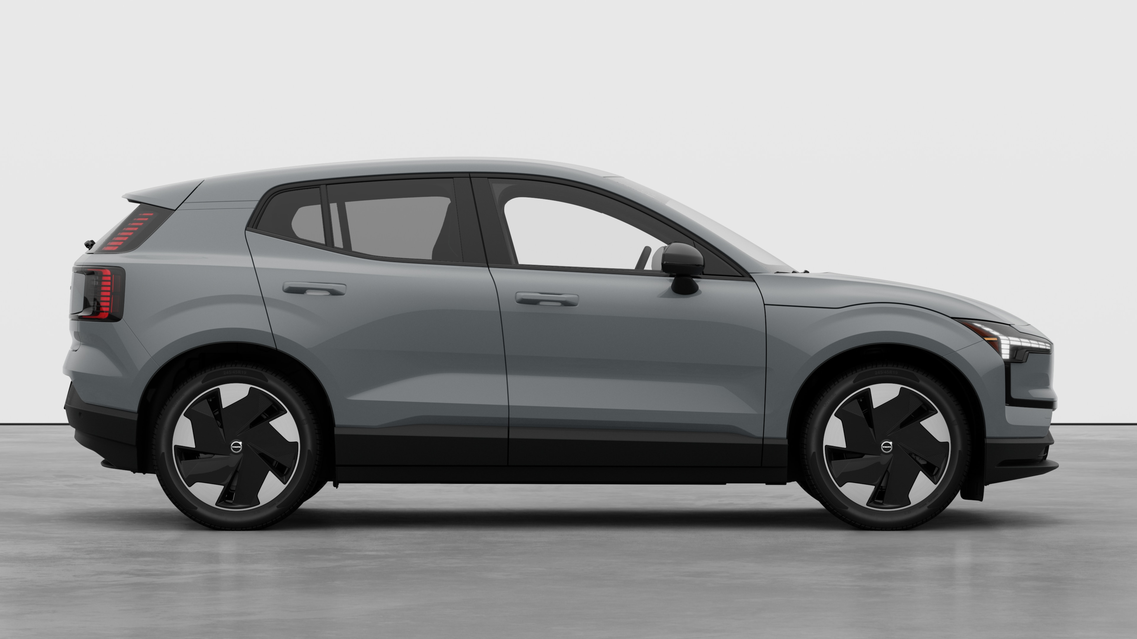 Volvo car side view on plain studio background displaying closed doors and visible wheel design.