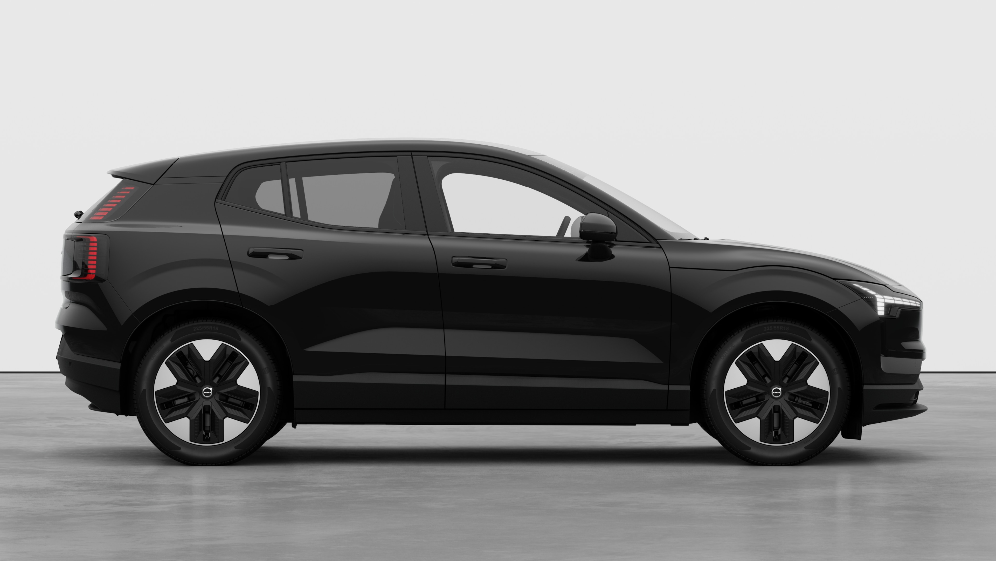 Zijaanzicht van een Volvo op een eenvoudige studioachtergrond met gesloten deuren en zichtbaar wielontwerp.