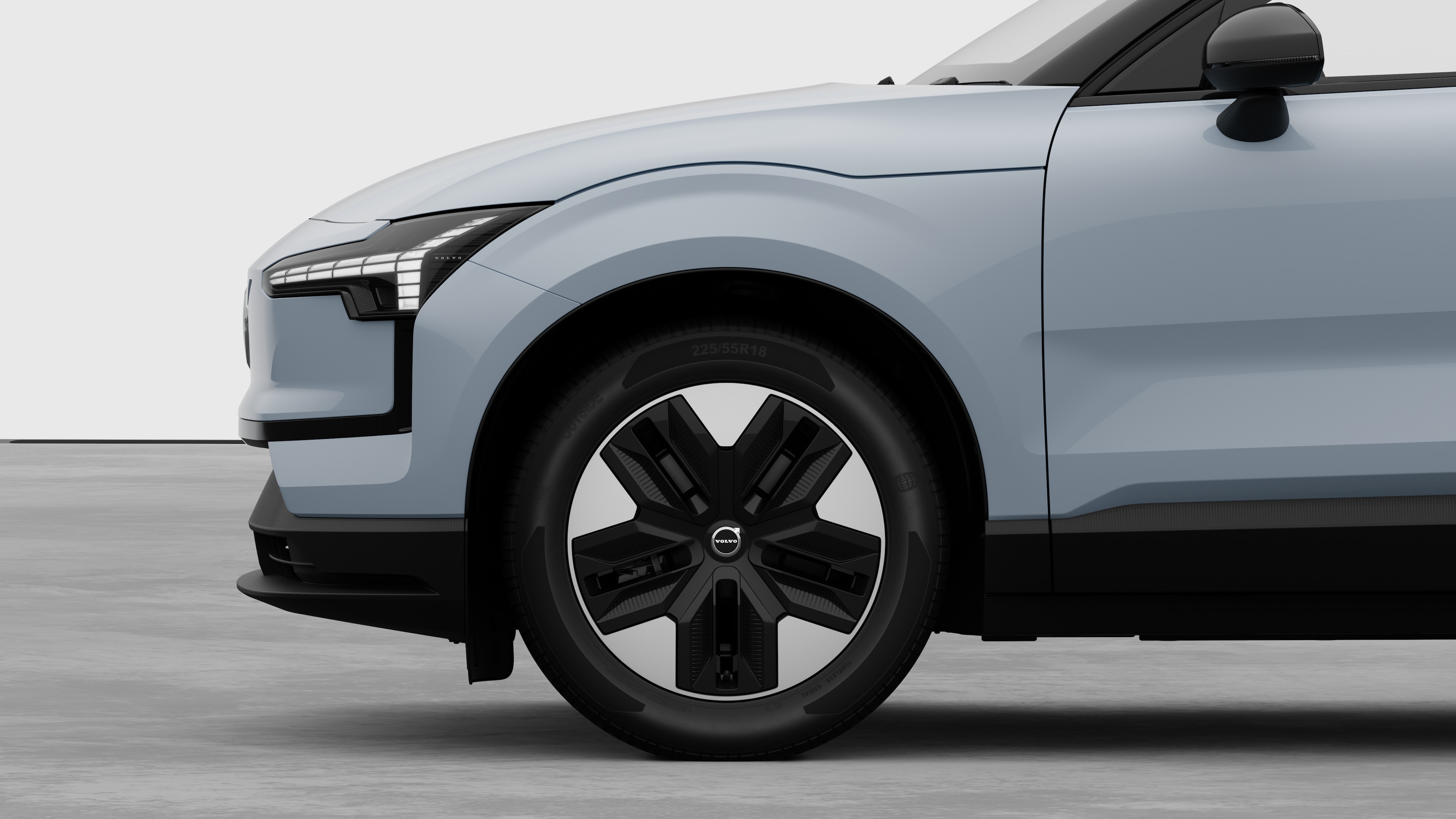 Volvo car exterior side view focusing on the front wheel and fender, set against a plain studio background.