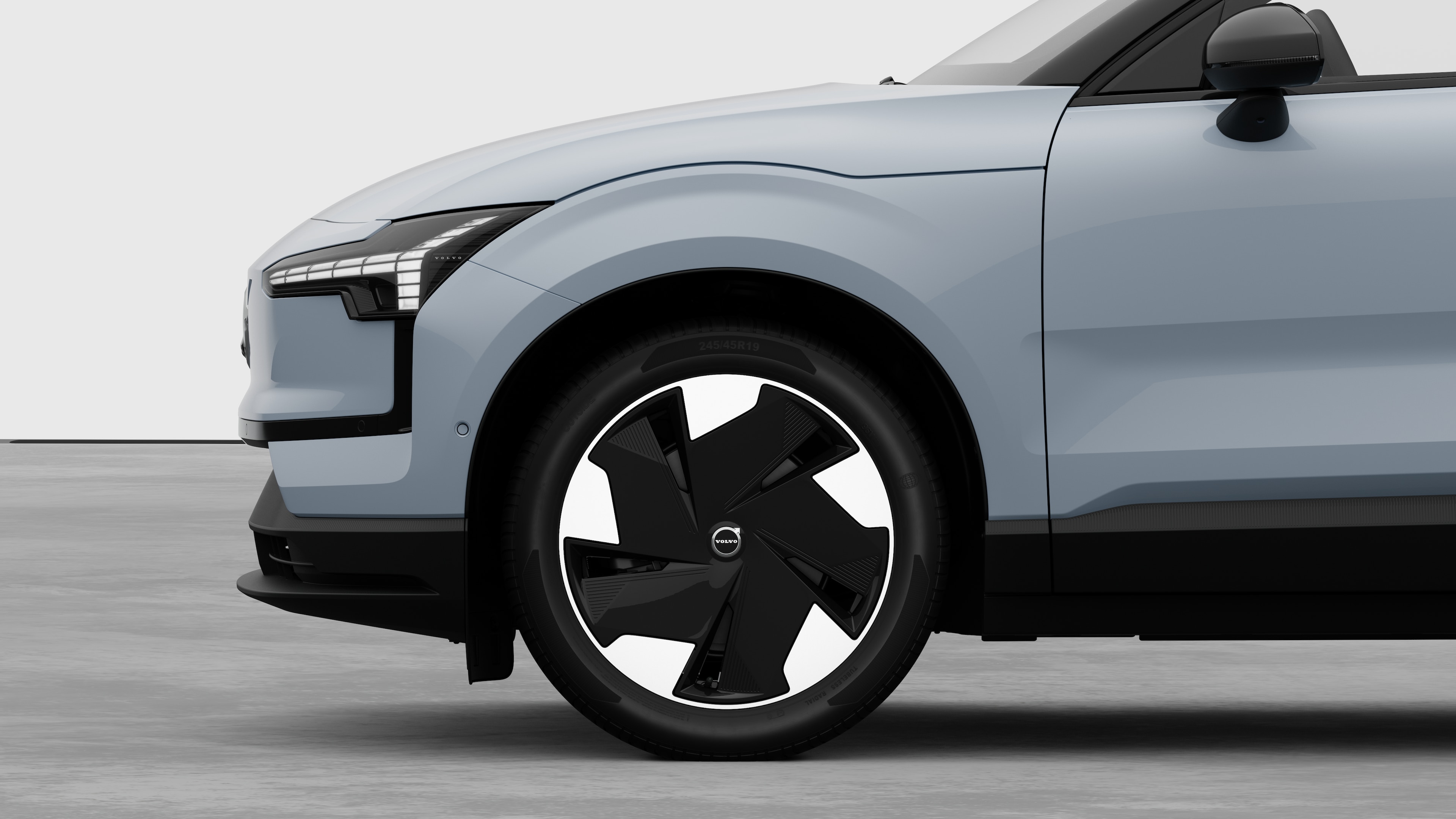 Vue latérale extérieure de la Volvo se concentrant sur la roue avant et l’aile, sur un fond de studio uni.