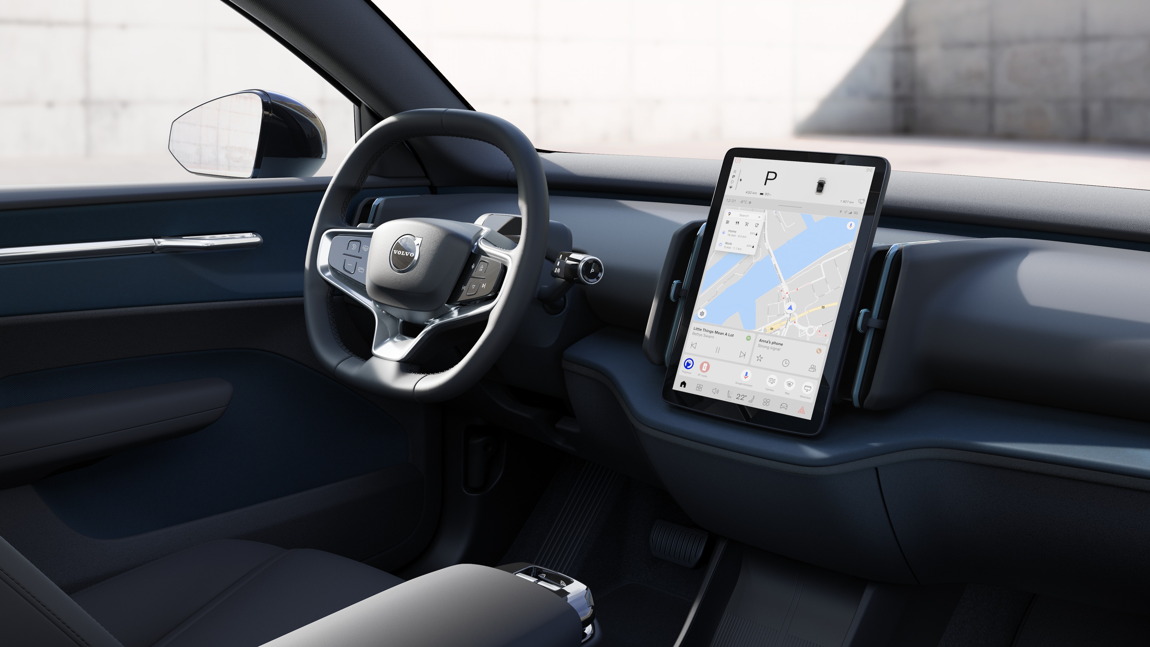 "Volvo" automobilio salone rodomas prietaisų skydelis, vairas ir centrinė konsolė su skaitmeniniu ekranu atvirame kelio fone.