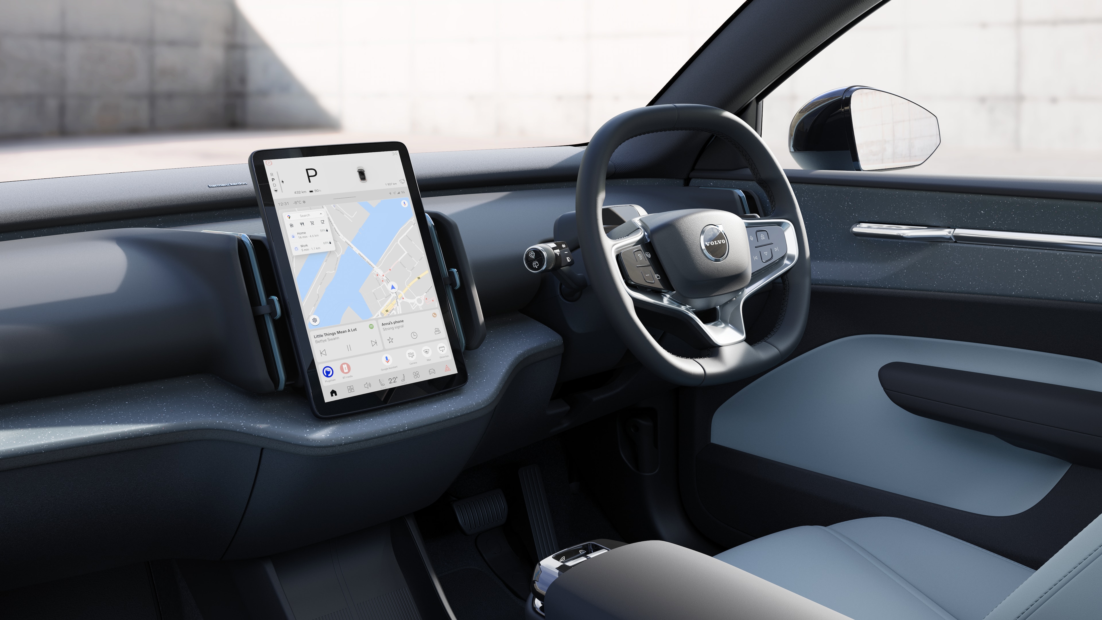 Volvo car interior showing dashboard, steering wheel, and center console with digital display in an open road background.