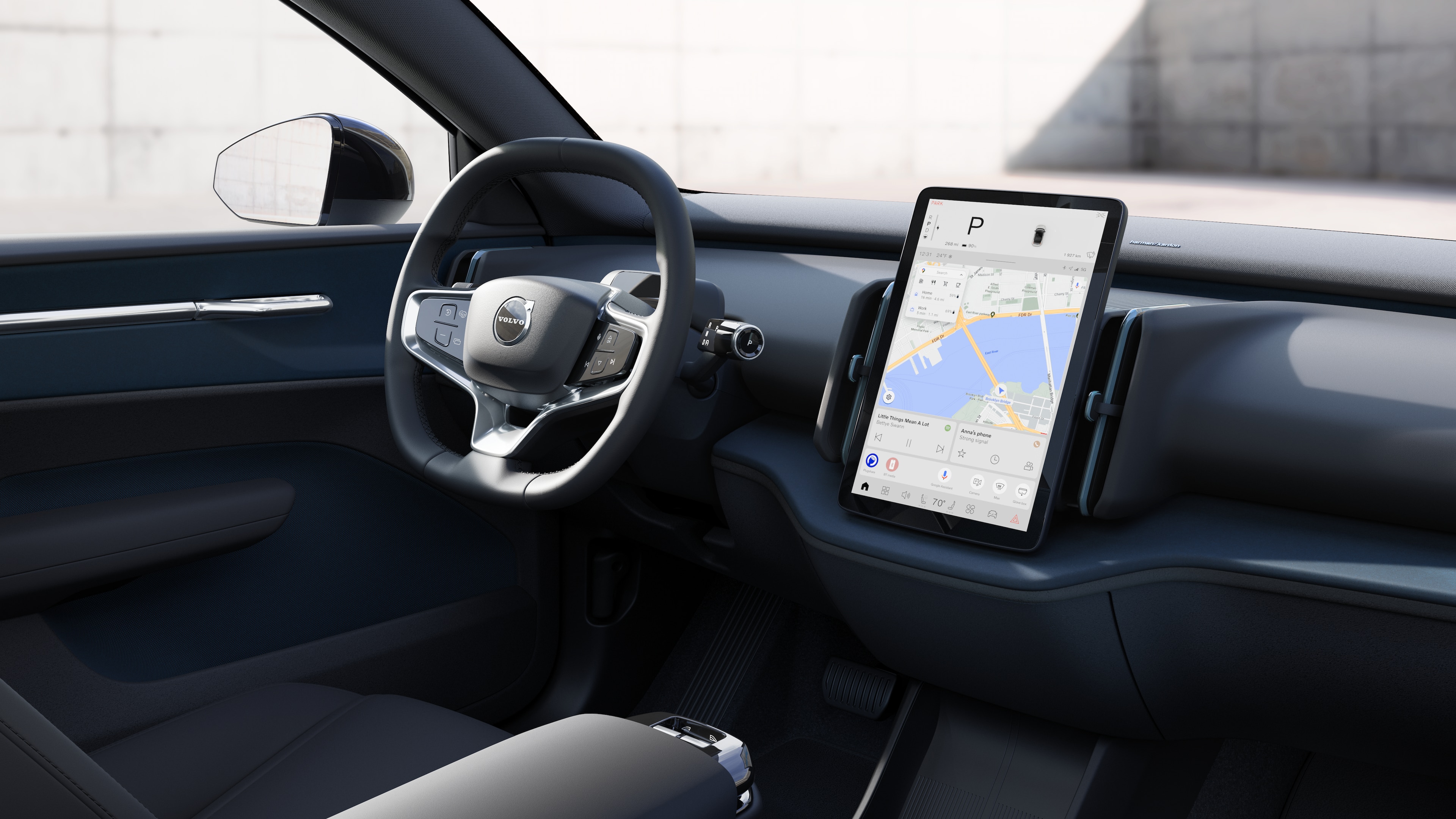 Volvo car interior showing dashboard, steering wheel, and center console with digital display in an open road background.