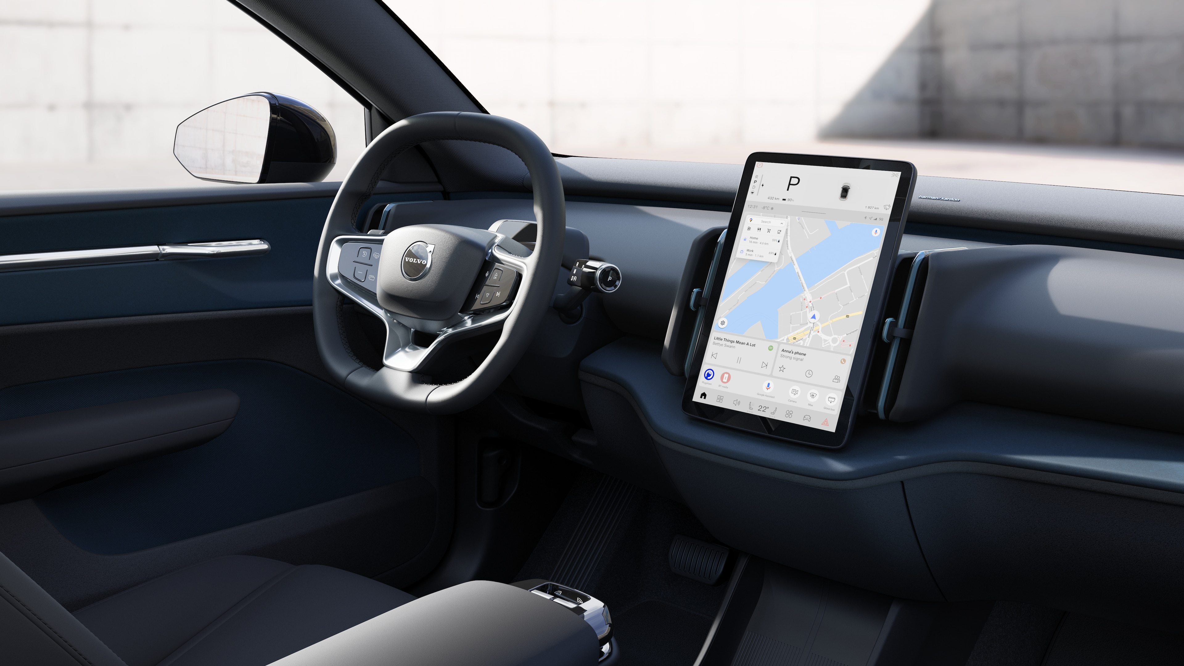 Interno di un'auto Volvo che mostra cruscotto, volante e console centrale con display digitale in una strada aperta.