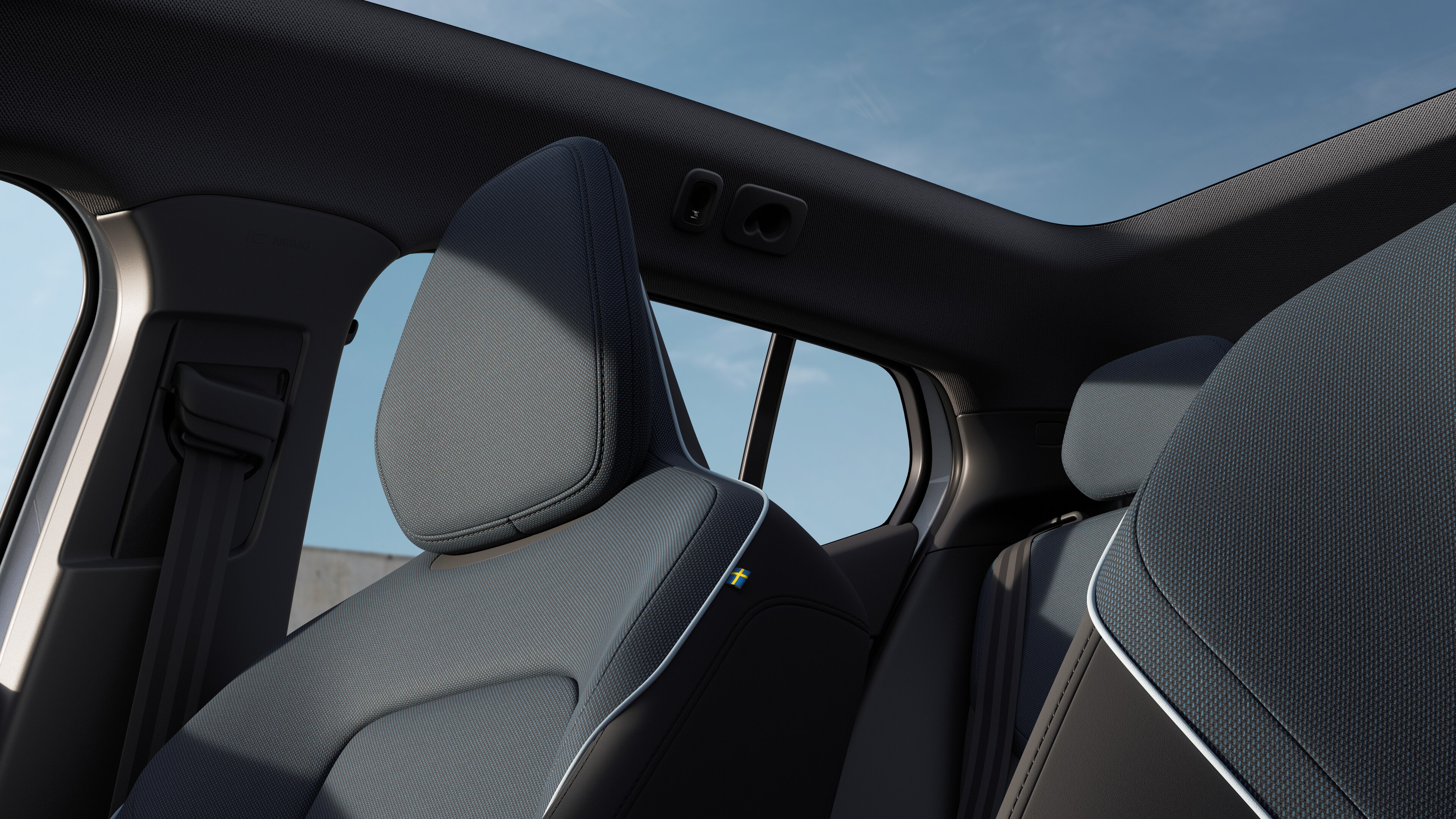 Volvo car interior showing front and rear passenger seats, steering wheel, dashboard, and center console against a plain studio background.