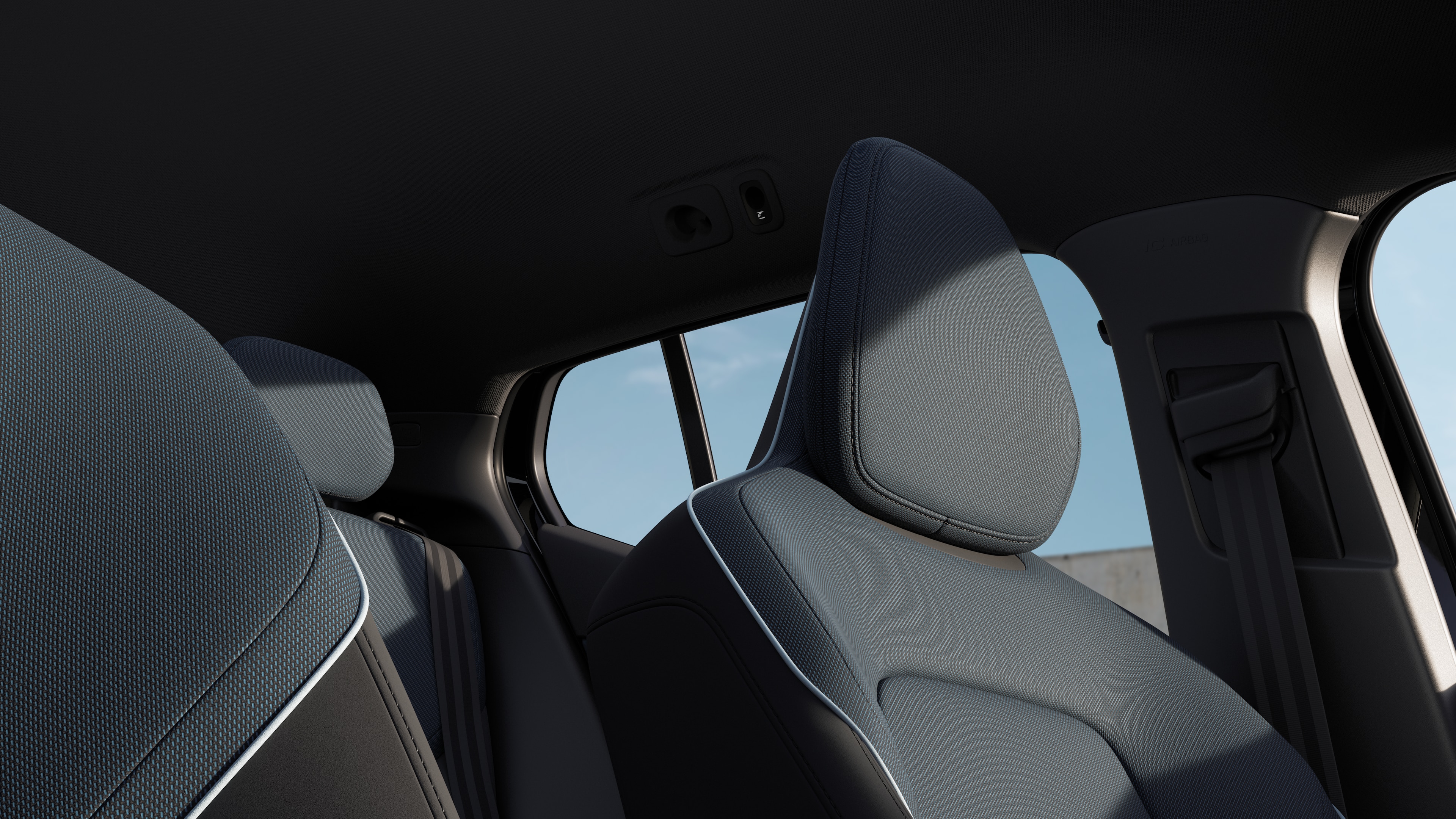 Volvo car interior showing front and rear passenger seats, steering wheel, dashboard, and center console against a plain studio background.