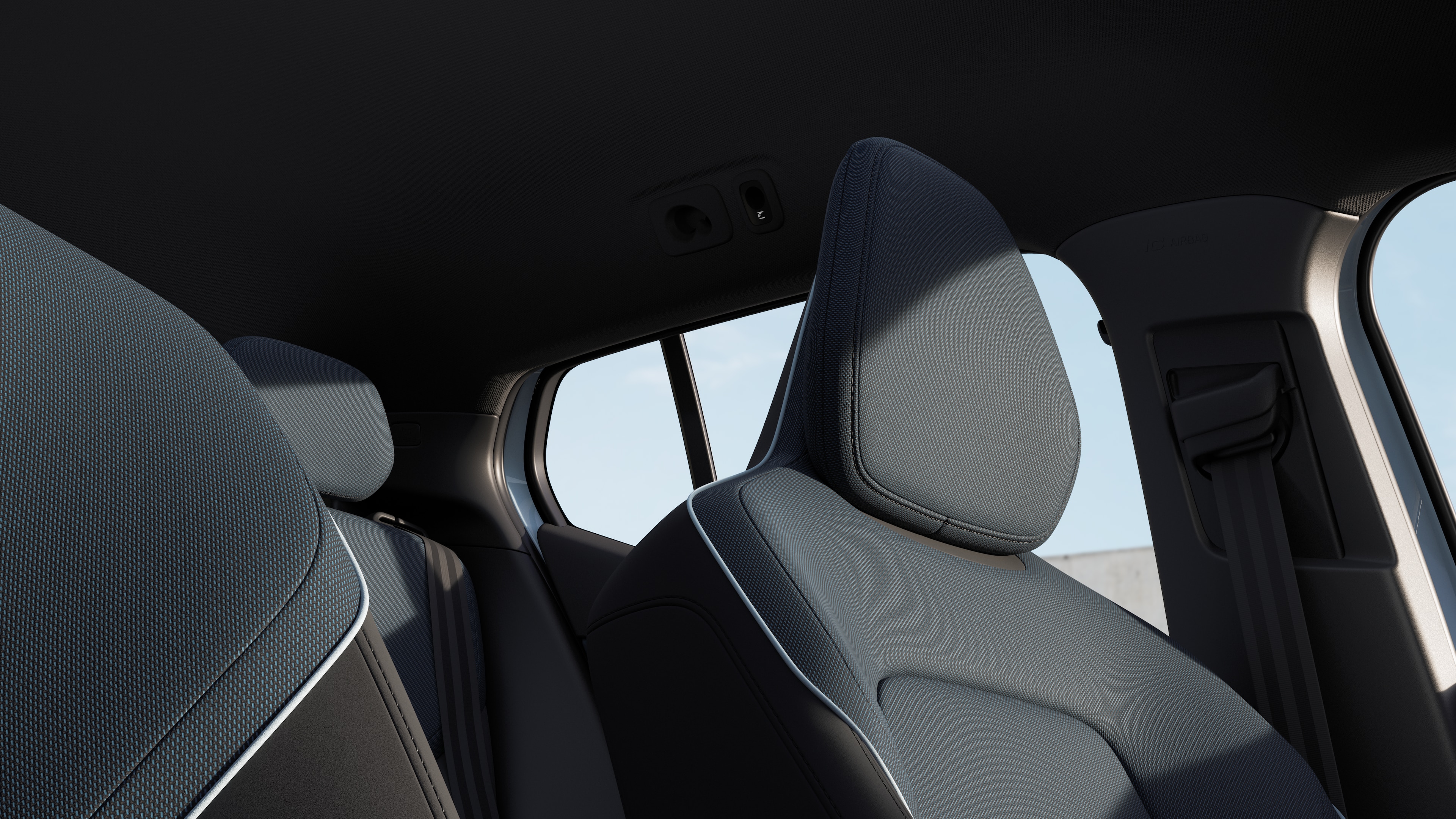 Volvo car interior showing front and rear passenger seats, steering wheel, dashboard, and center console against a plain studio background.