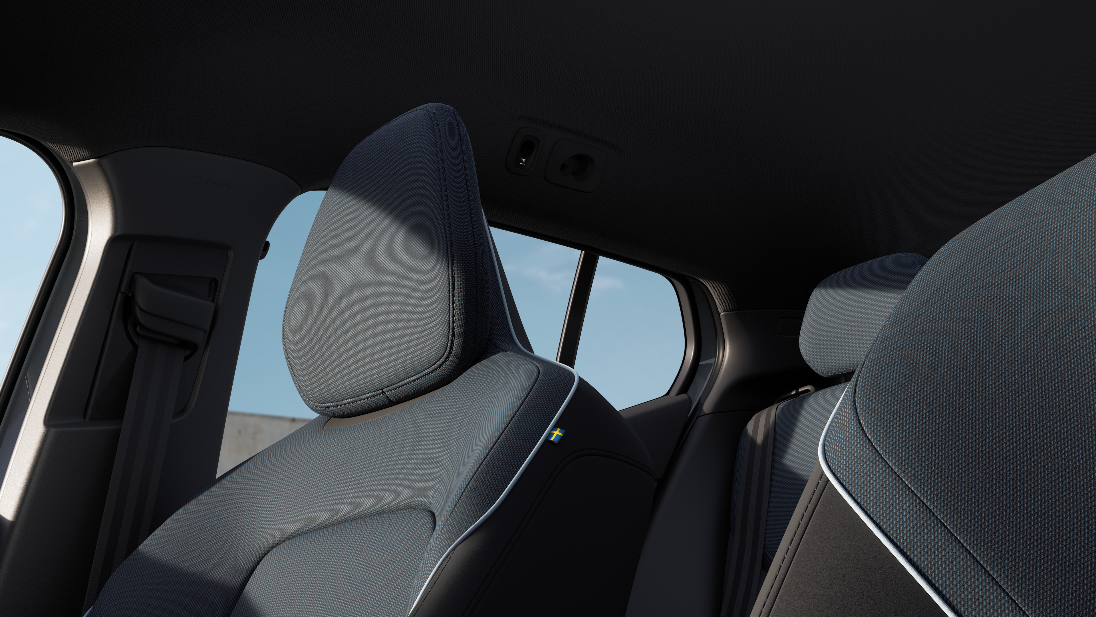 Volvo car interior showing front and rear passenger seats, steering wheel, dashboard, and center console against a plain studio background.
