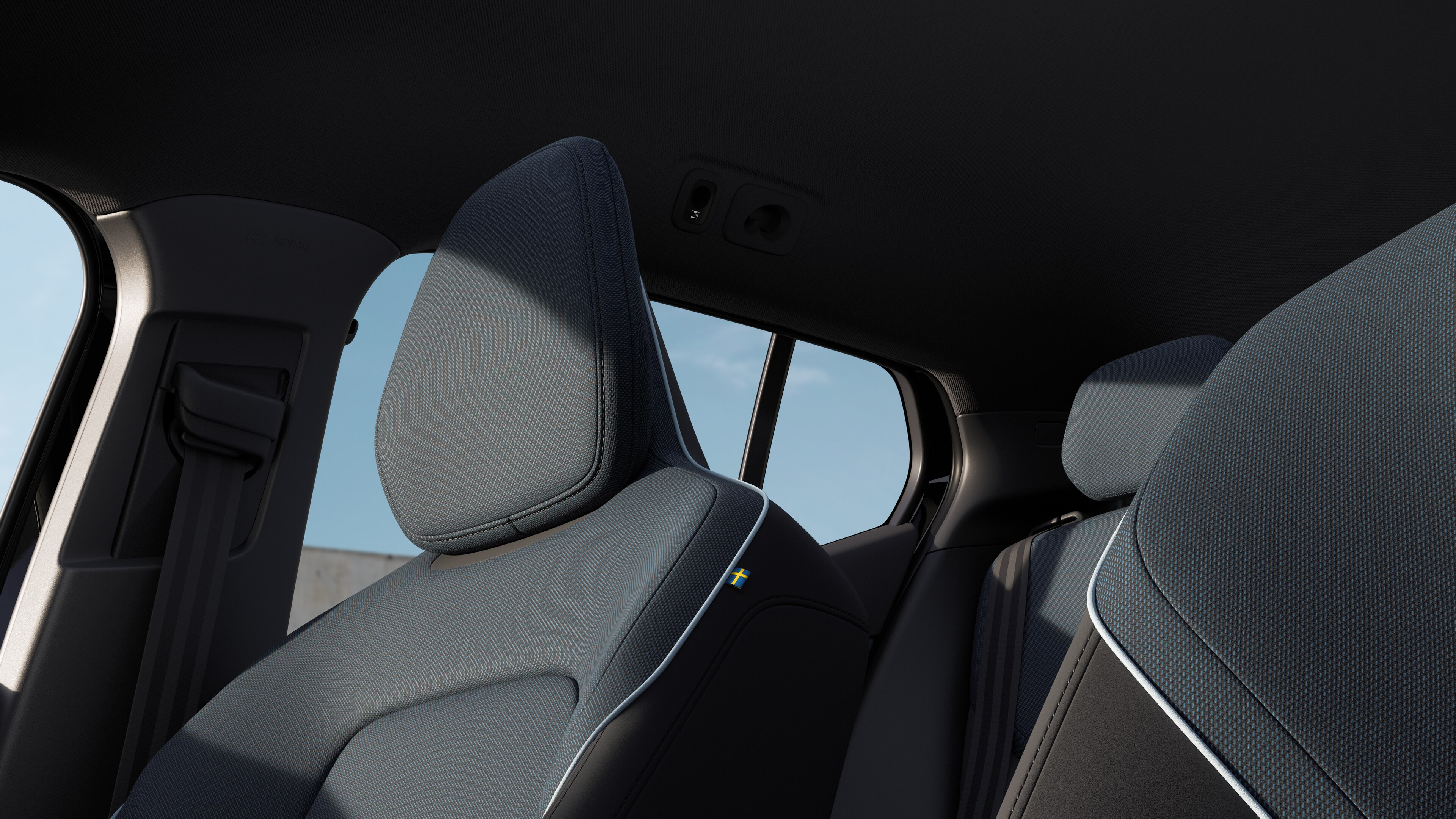 Volvo-interiör som visar passagerarsäten fram och bak, ratt, instrumentbräda och mittkonsol mot en enkel studiobakgrund.