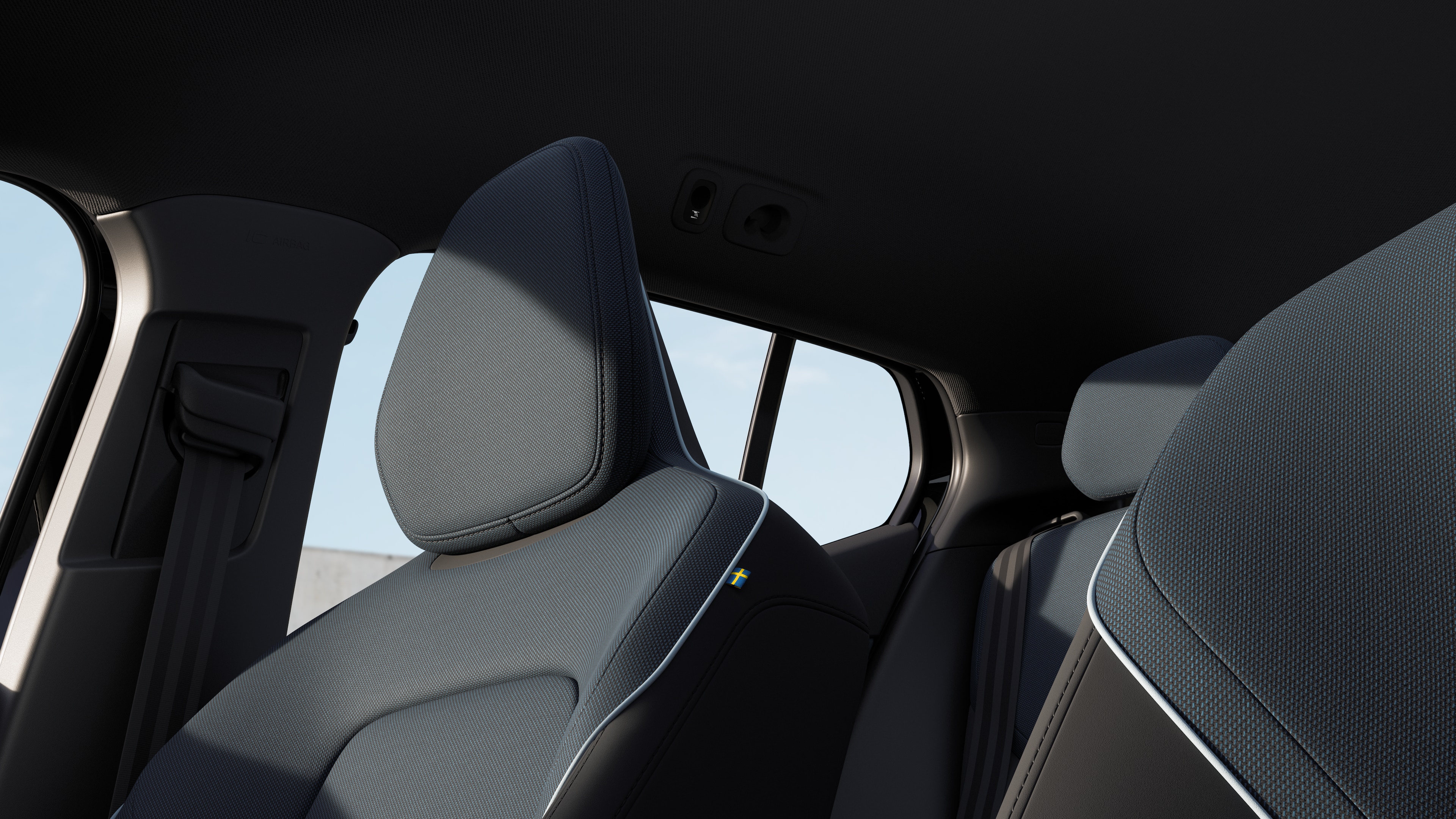 Interno di un'auto Volvo che mostra i sedili dei passeggeri anteriori e posteriori, il volante, il cruscotto e la console centrale su uno sfondo semplice in studio.