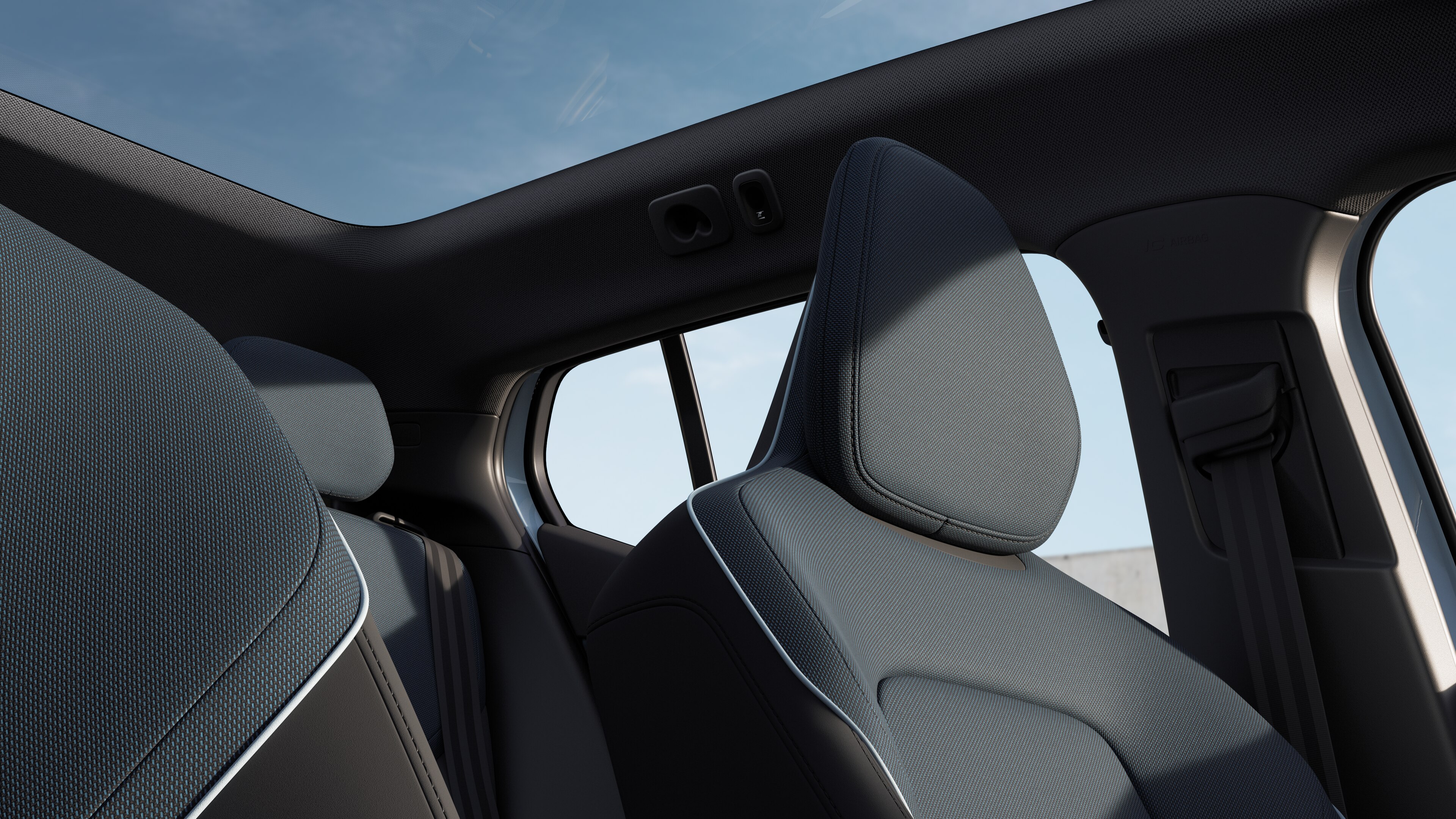 Volvo car interior showing front and rear passenger seats, steering wheel, dashboard, and center console against a plain studio background.