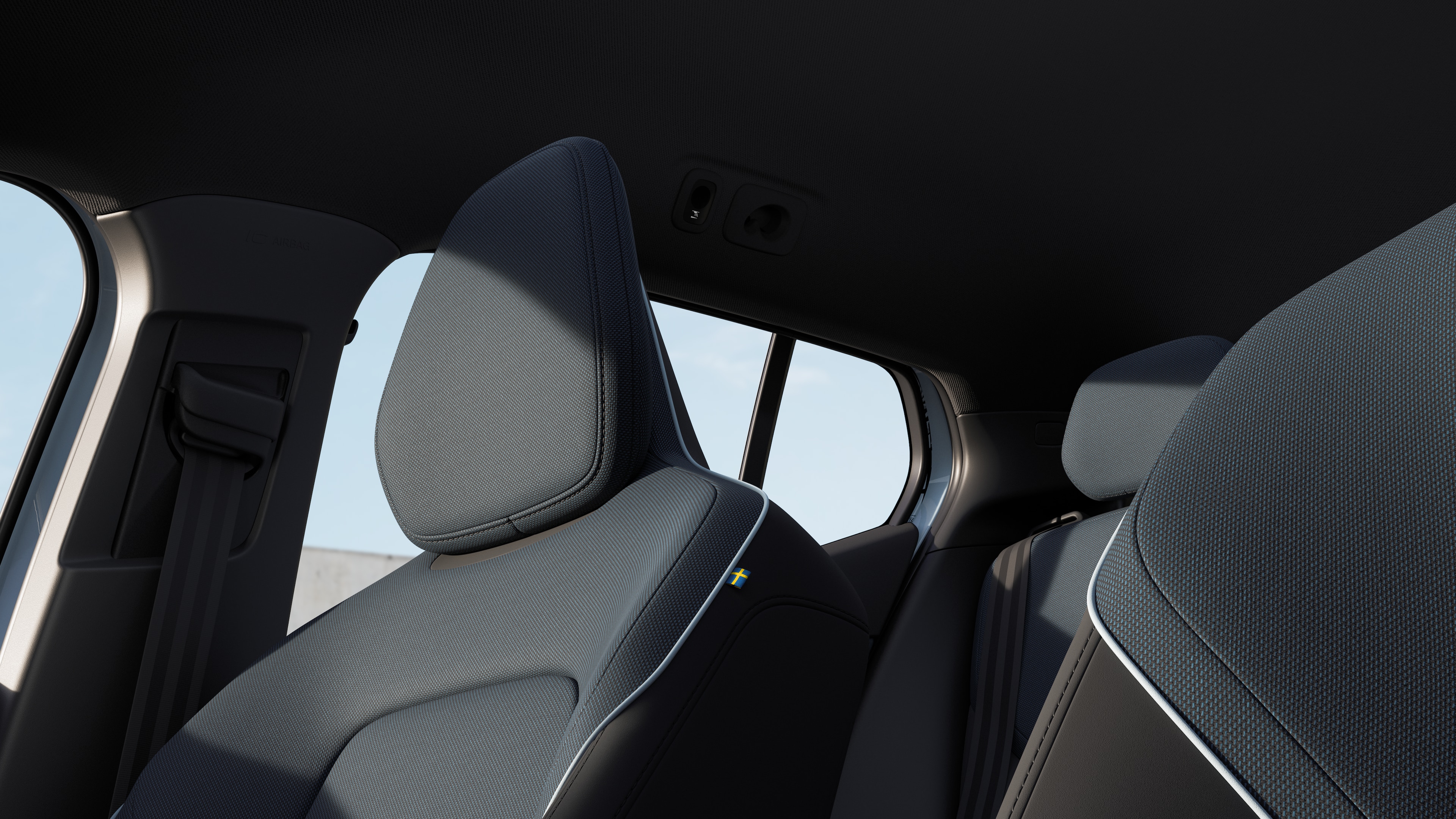 Intérieur Volvo montrant les sièges passagers avant et arrière, le volant, le tableau de bord et la console centrale sur un fond de studio uni.