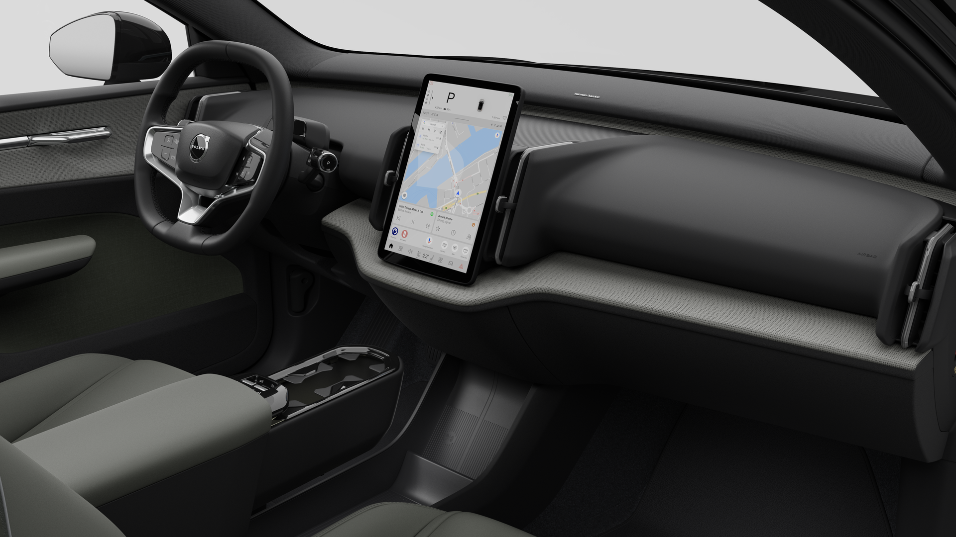 Vue intérieure d’une Volvo montrant le tableau de bord, le volant, la console centrale et l’écran d’affichage numérique sur un fond de studio uni.