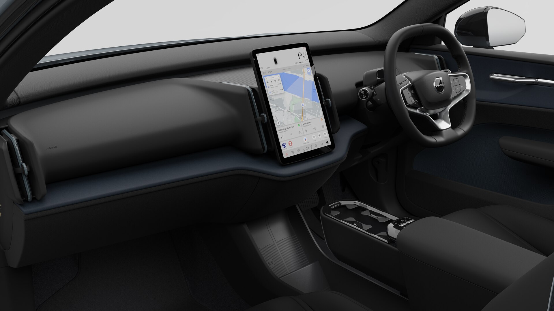 Interior view of a Volvo car showing the dashboard, steering wheel, centre console, and digital display screen in a plain studio background.