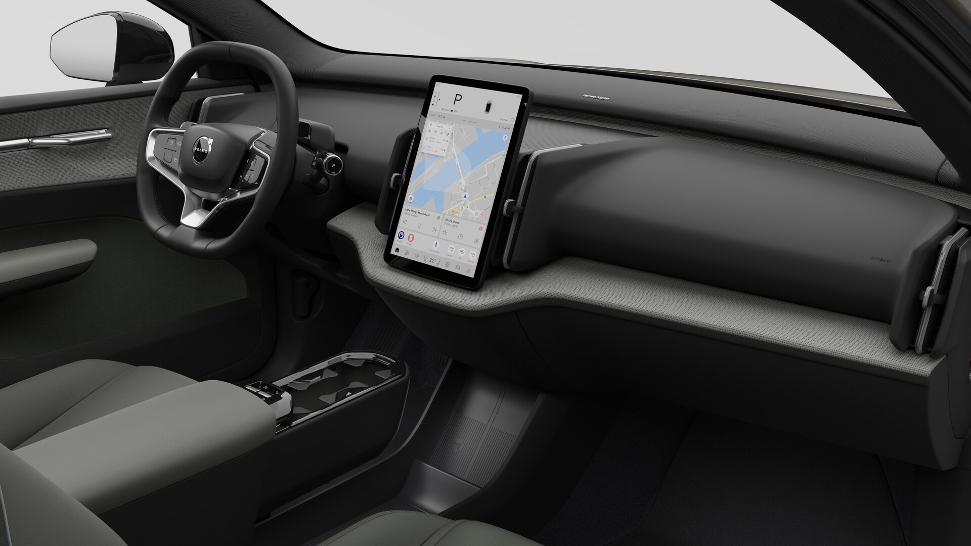 Vue intérieure d’une Volvo montrant le tableau de bord, le volant, la console centrale et l’écran d’affichage numérique sur un fond de studio uni.