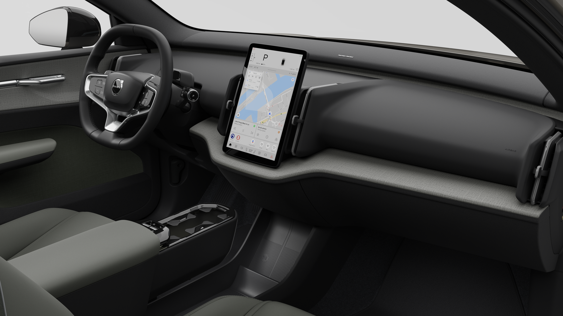 Vue intérieure d’une Volvo montrant le tableau de bord, le volant, la console centrale et l’écran d’affichage numérique sur un fond de studio uni.