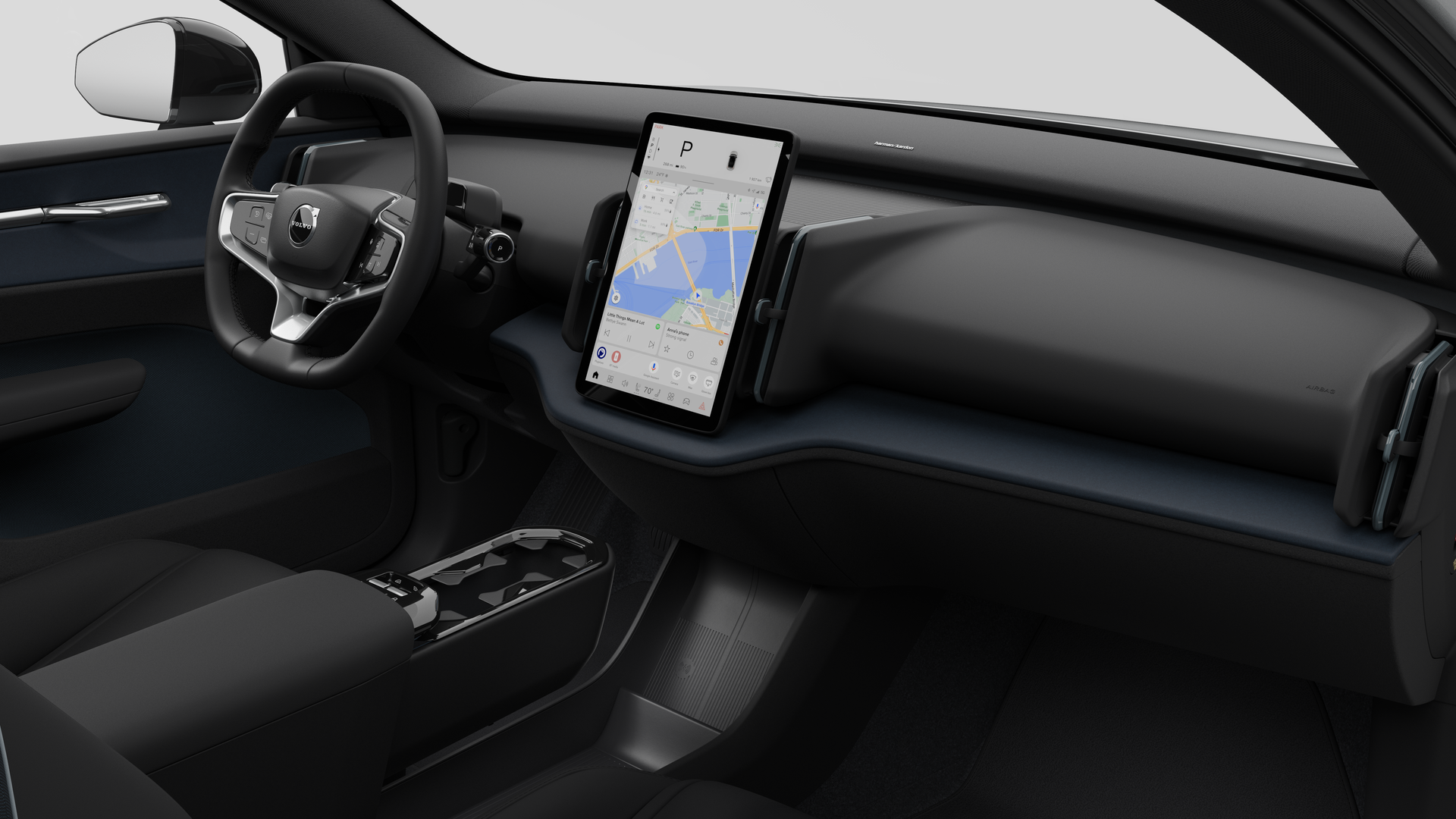 Interior view of a Volvo car showing the dashboard, steering wheel, center console, and digital display screen in a plain studio background.