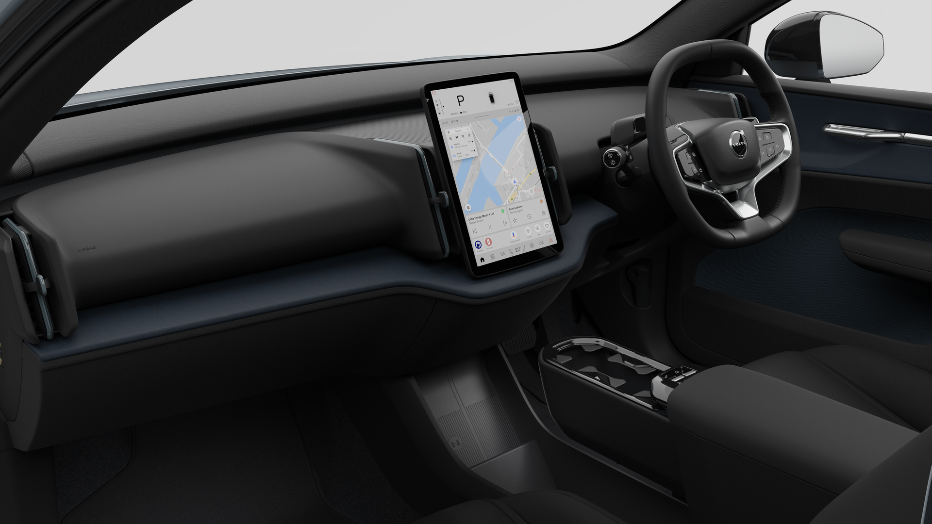 Interior view of a Volvo car showing the dashboard, steering wheel, center console, and digital display screen in a plain studio background.