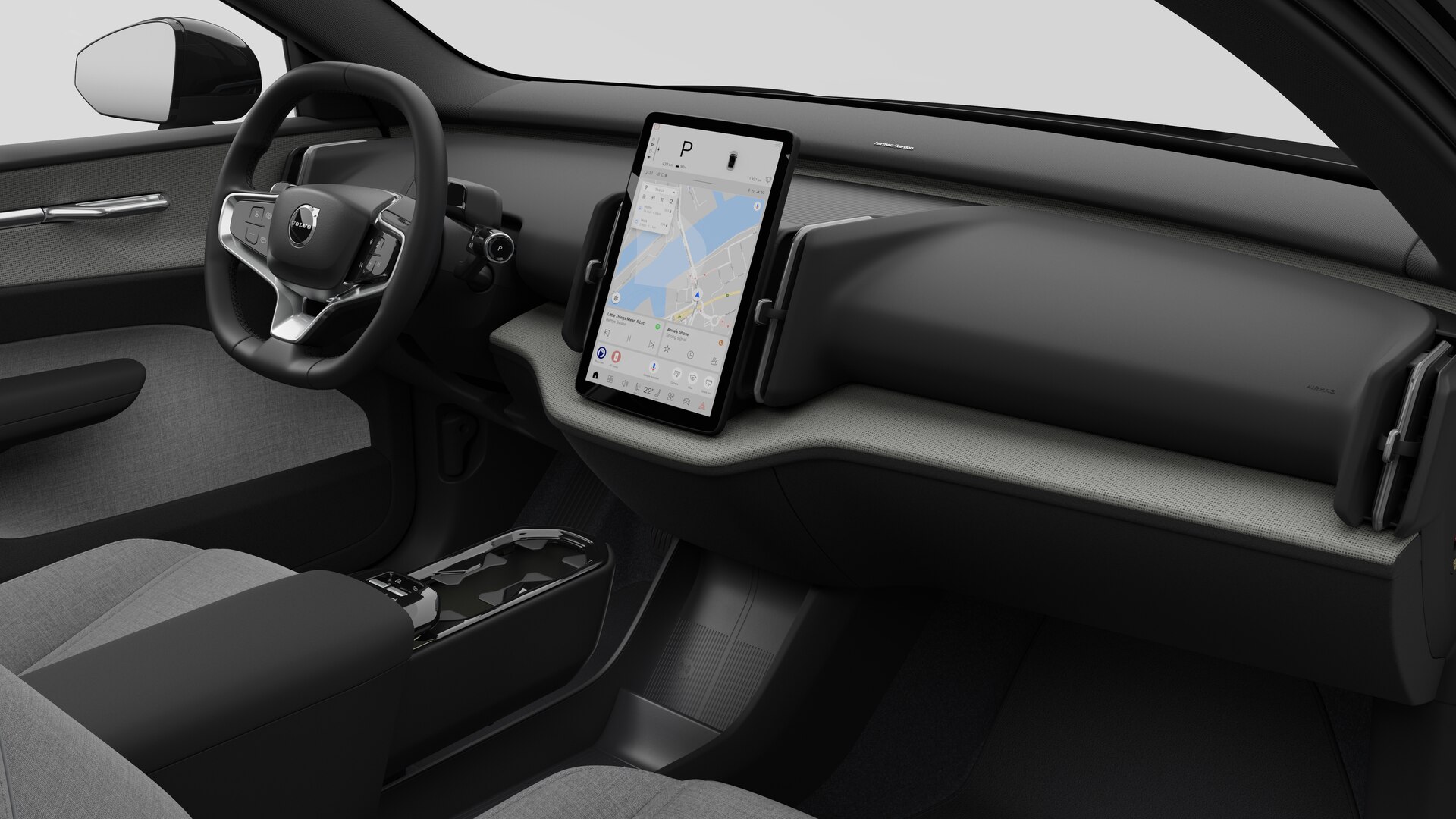 Vue intérieure d’une Volvo montrant le tableau de bord, le volant, la console centrale et l’écran d’affichage numérique sur un fond de studio uni.