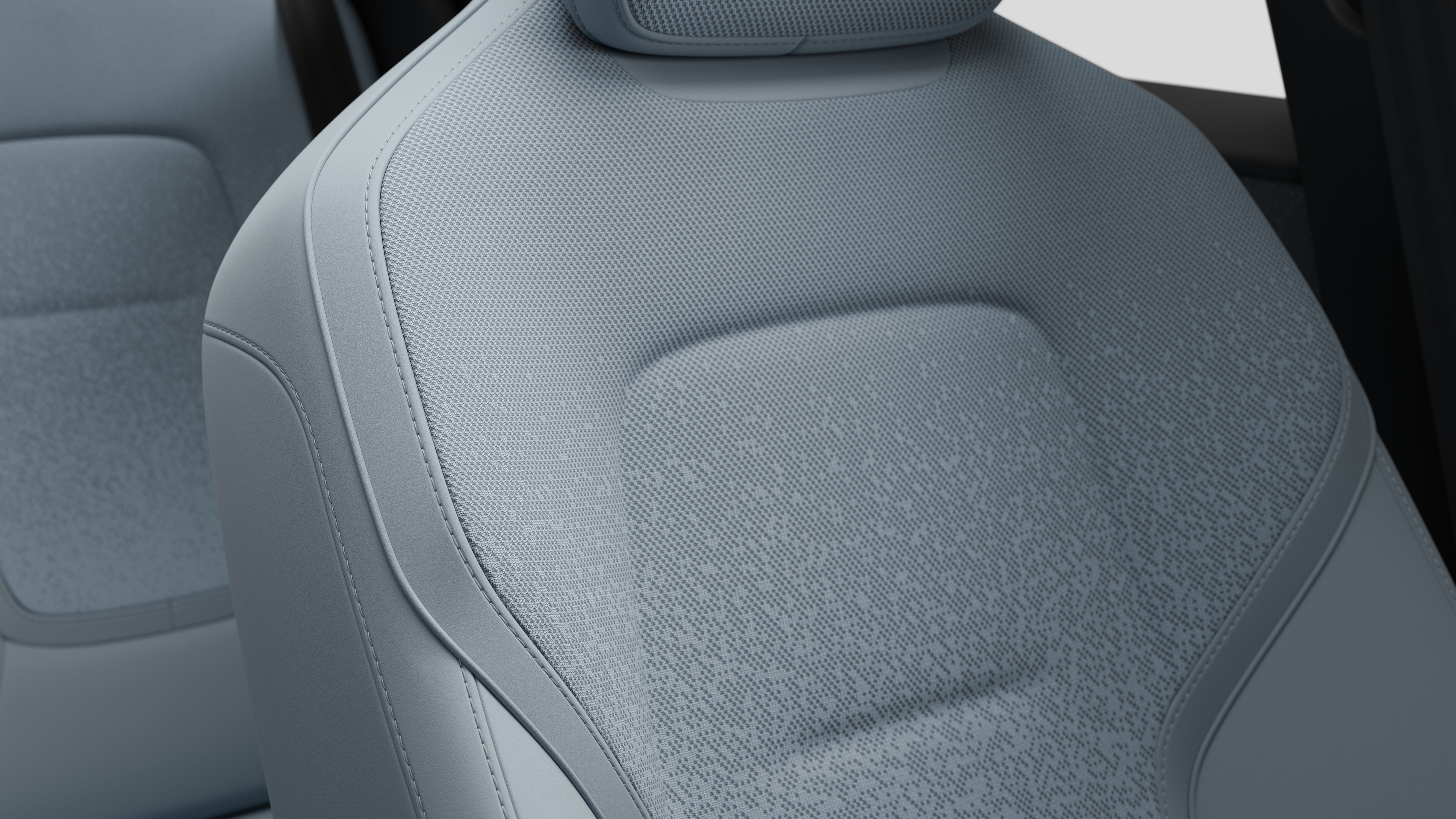 Close-up of Volvo car interior seat detail showing stitching and a small Swedish flag tag.