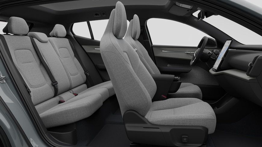 Sidovy av Volvobilens interiör som visar framsäten, bakre passagerarsäten, ratt, instrumentbräda och mittkonsol mot en vanlig studiobakgrund.