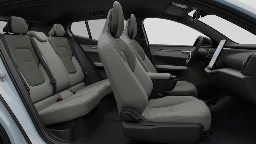 Zijaanzicht van het interieur van een Volvo met de voorstoelen, de passagiersstoelen achterin, het stuur, het dashboard en de middenconsole, tegen een effen studioachtergrond.