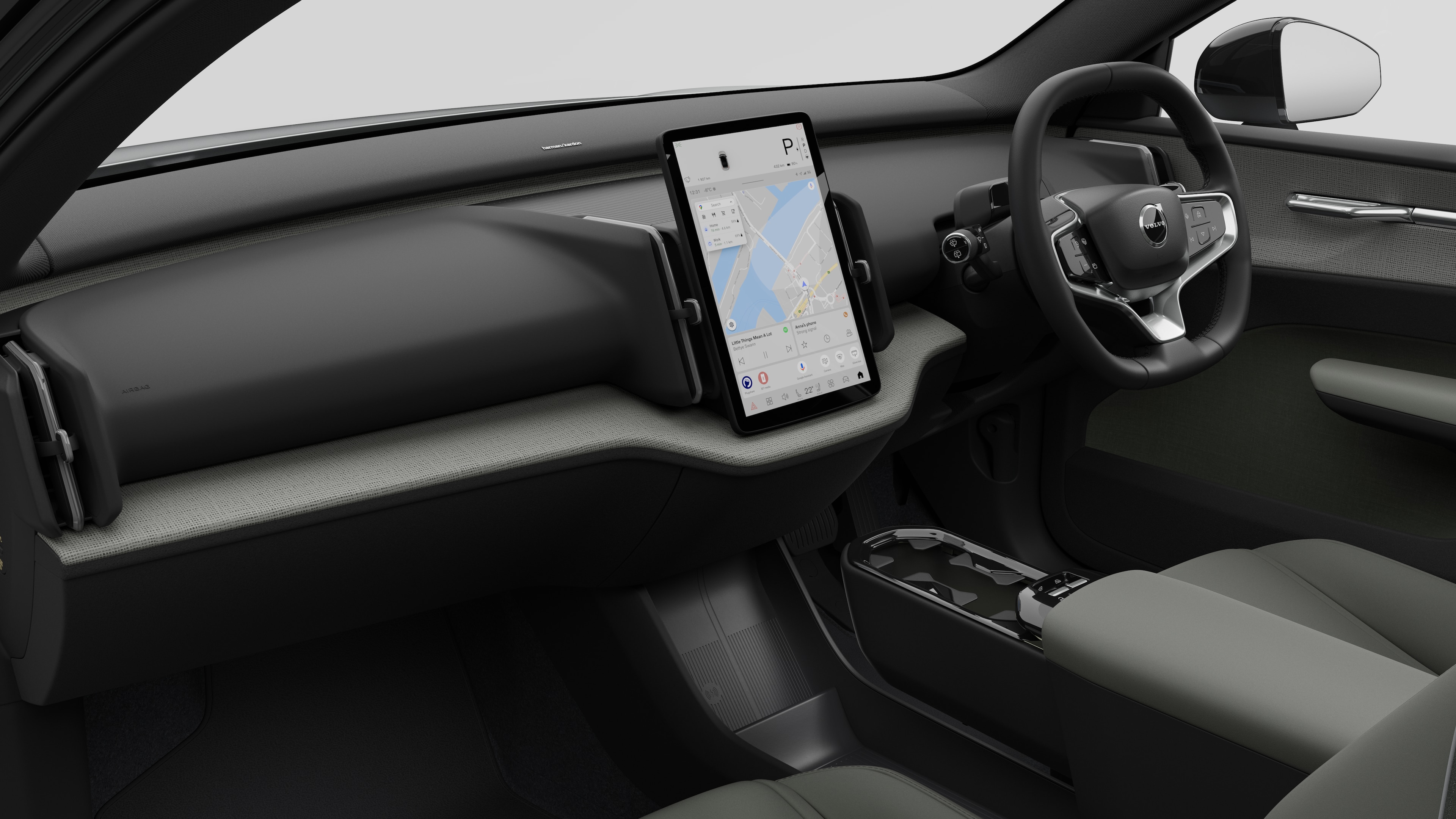 簡素なスタジオ背景にダッシュボード、ステアリングホイール、センターコンソール、デジタルディスプレイ画面を映し出すボルボ車のインテリア画像。