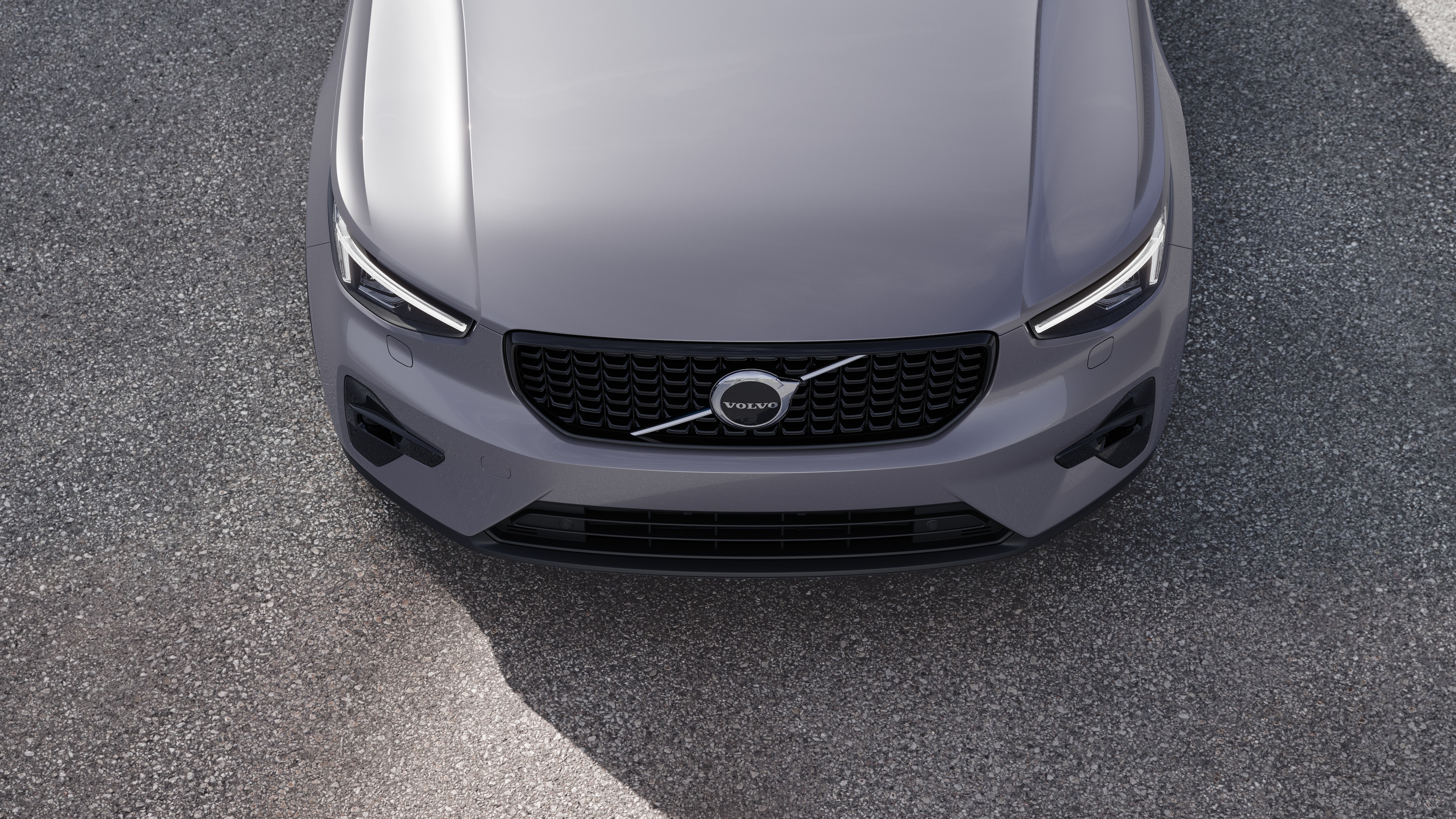 Volvobilens exteriör i trekvartsvy mot en urban gatubakgrund, som visar ena sidan, taket och en del av fronten.