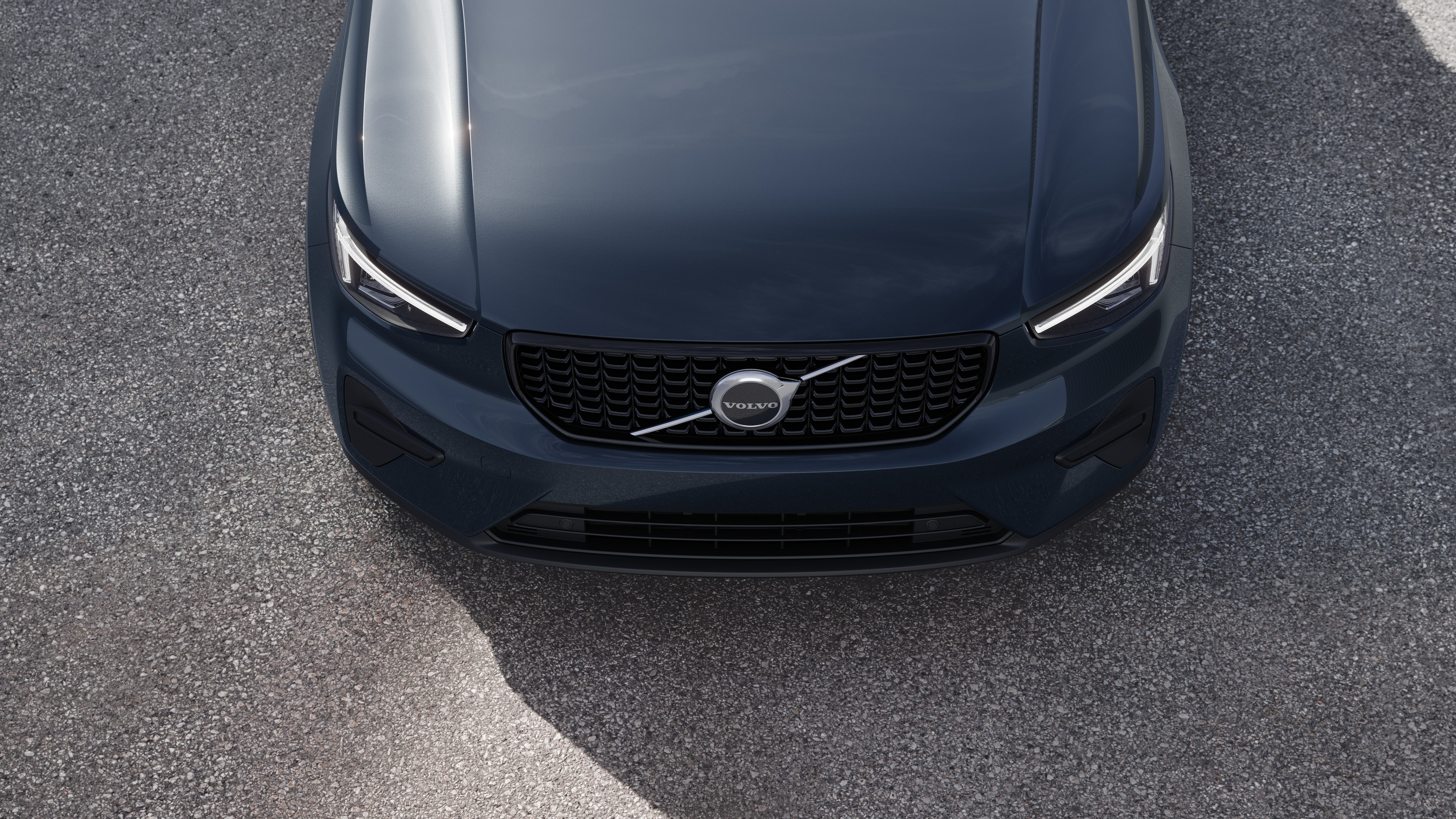 Volvo car exterior in three-quarter view on an urban street background, showing one side, roof, and part of the front.