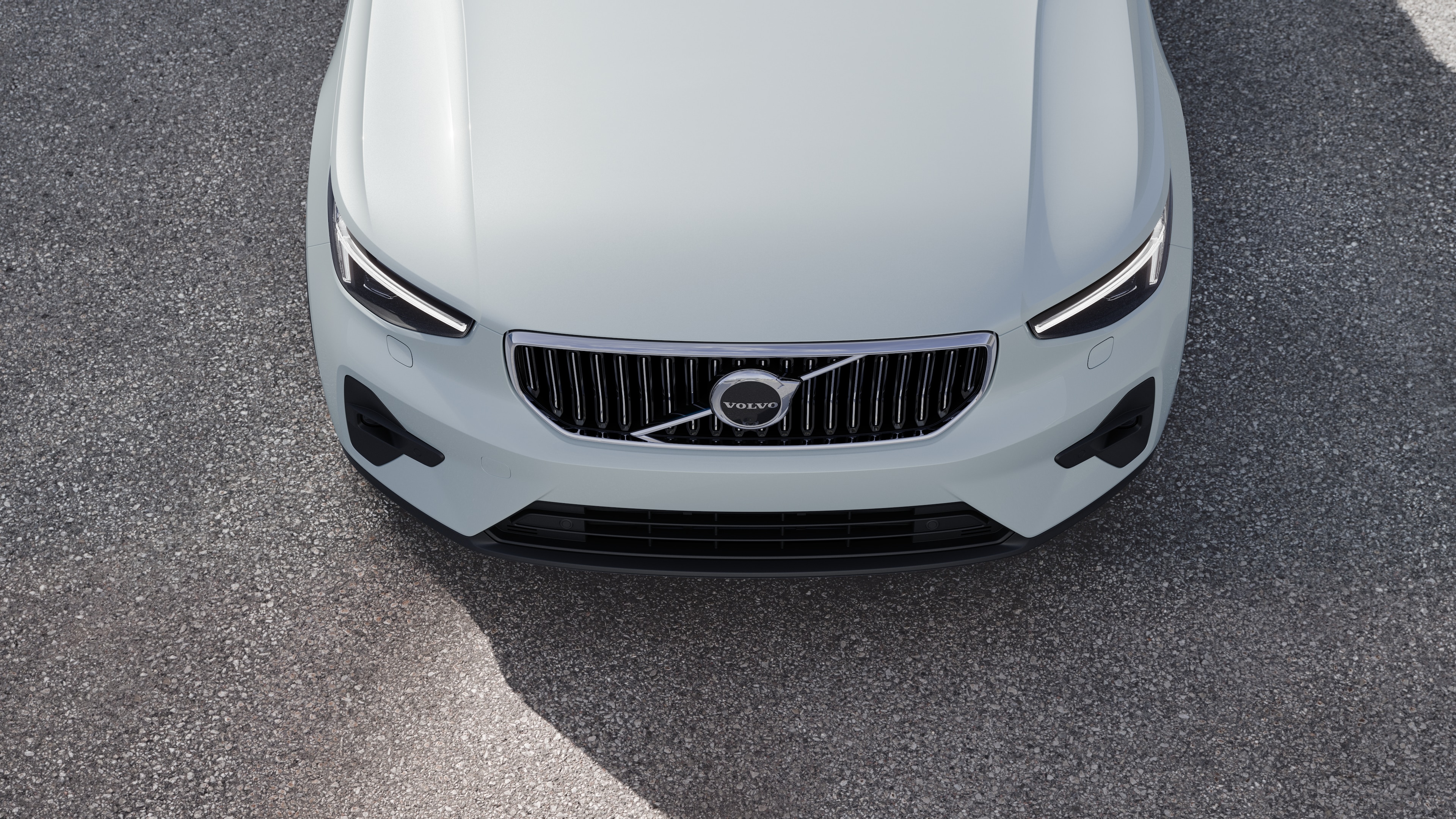 Volvo car exterior in three-quarter view on an urban street background, showing one side, roof, and part of the front.