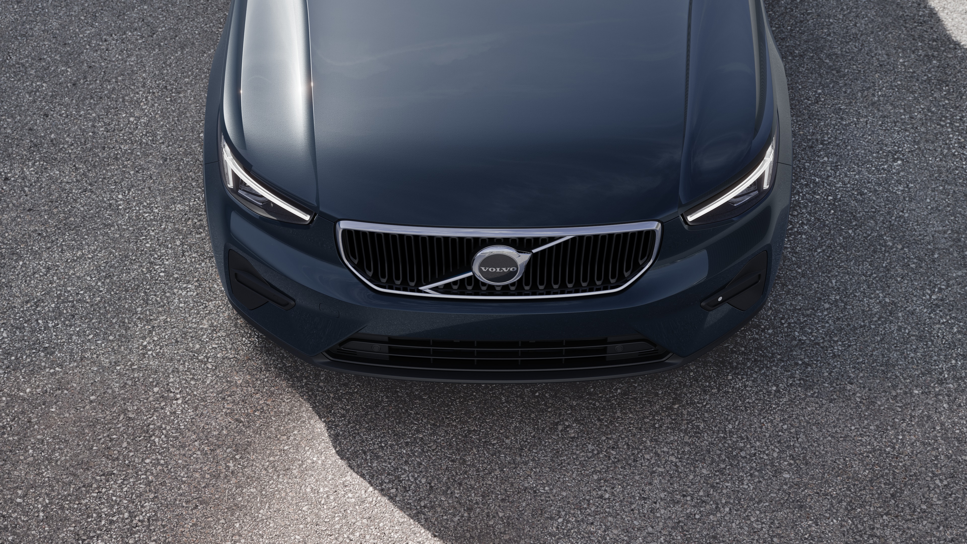 Exteriorul mașinii Volvo într-o vedere pe trei sferturi pe un fundal de stradă urbană, arătând o parte, acoperișul și o parte din față.
