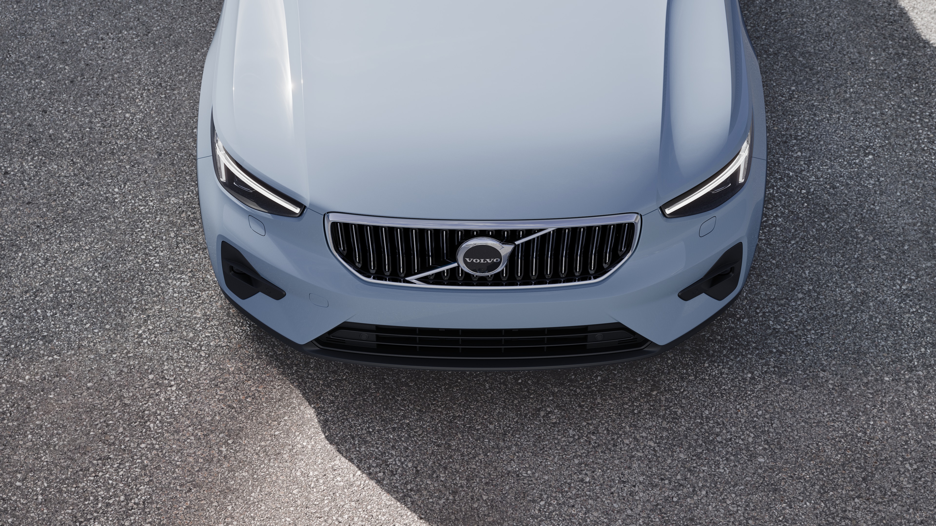 Volvo car exterior in three-quarter view on an urban street background, showing one side, roof, and part of the front.