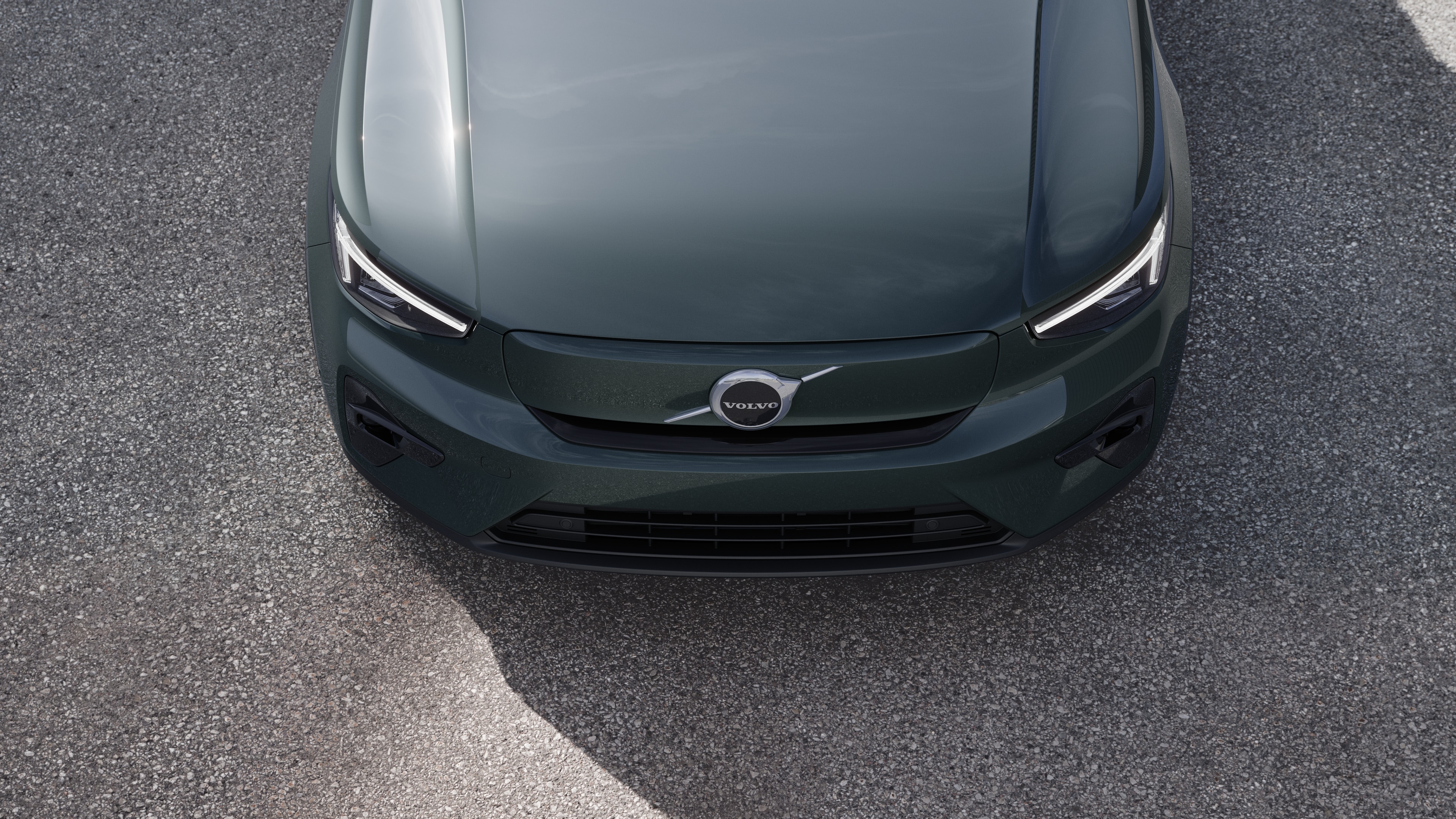 Volvo car exterior in three-quarter view on an urban street background, showing one side, roof, and part of the front.