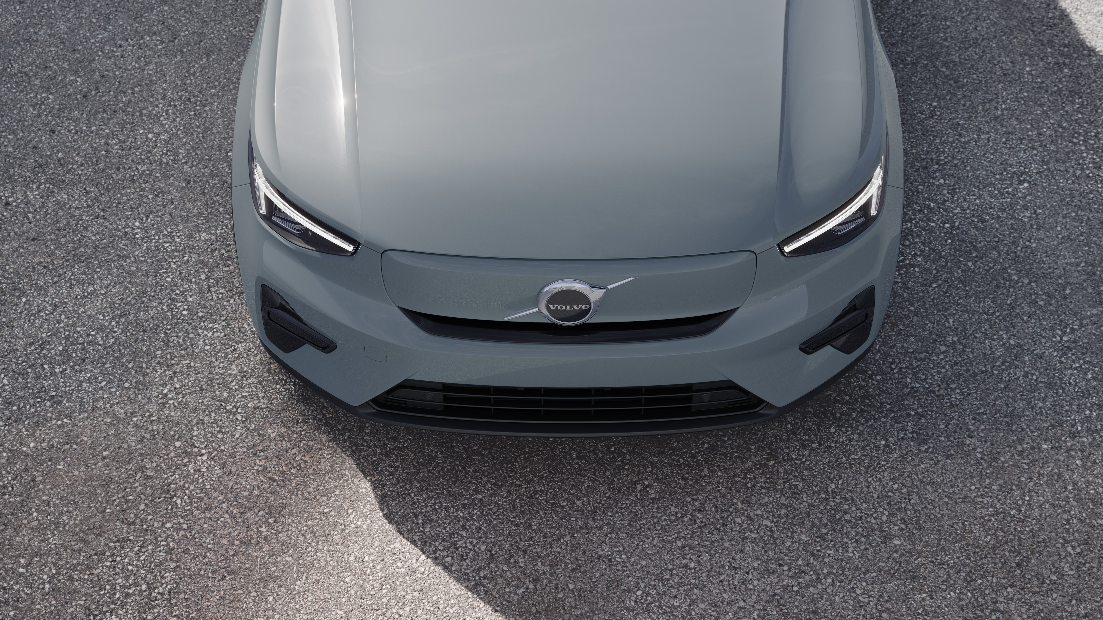 "Volvo" automobilio išorė su trijų ketvirčių vaizdu miesto gatvės fone, parodant vieną pusę, stogą ir dalį priekio.