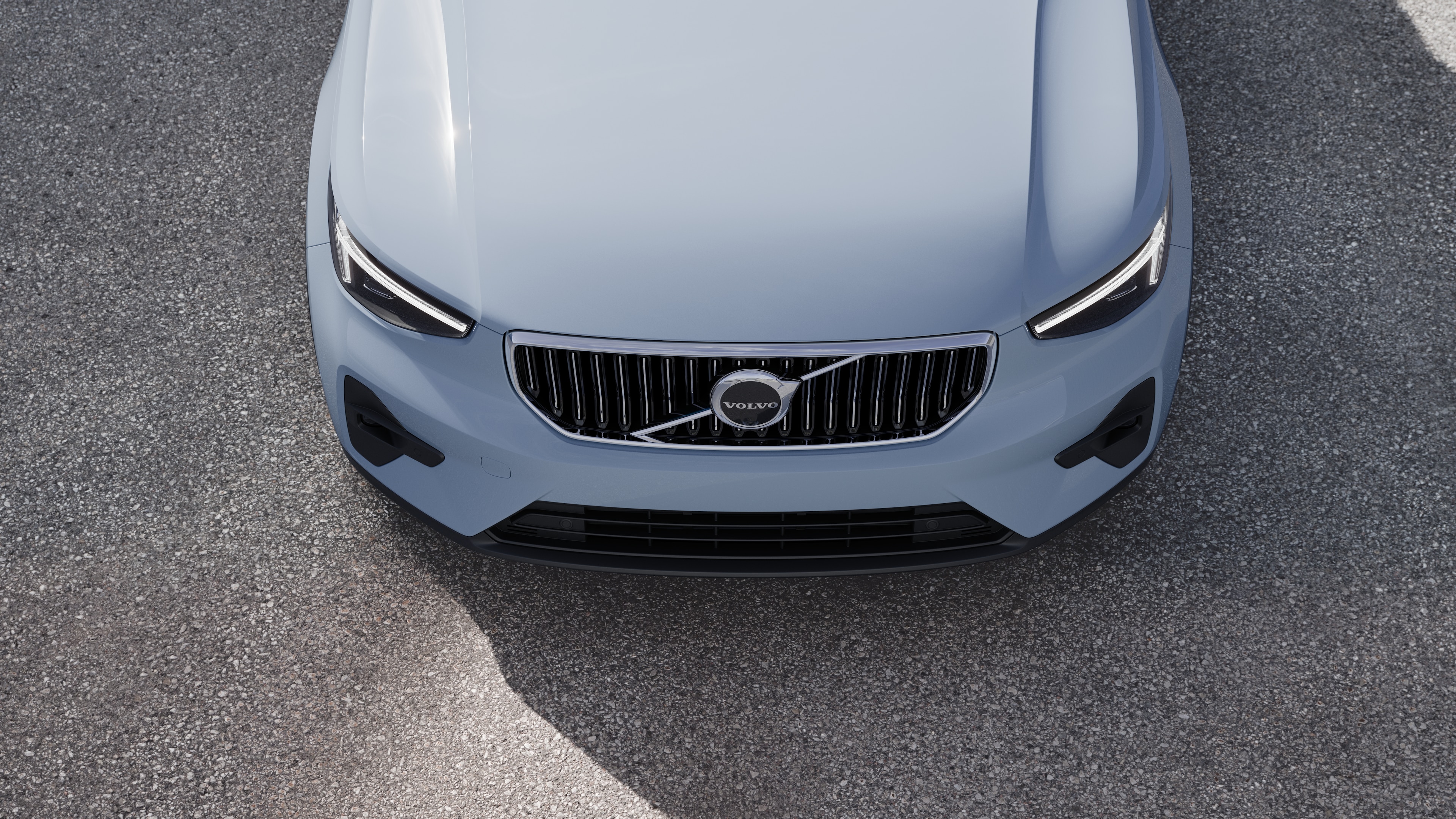 Volvo car exterior in three-quarter view on an urban street background, showing one side, roof, and part of the front.