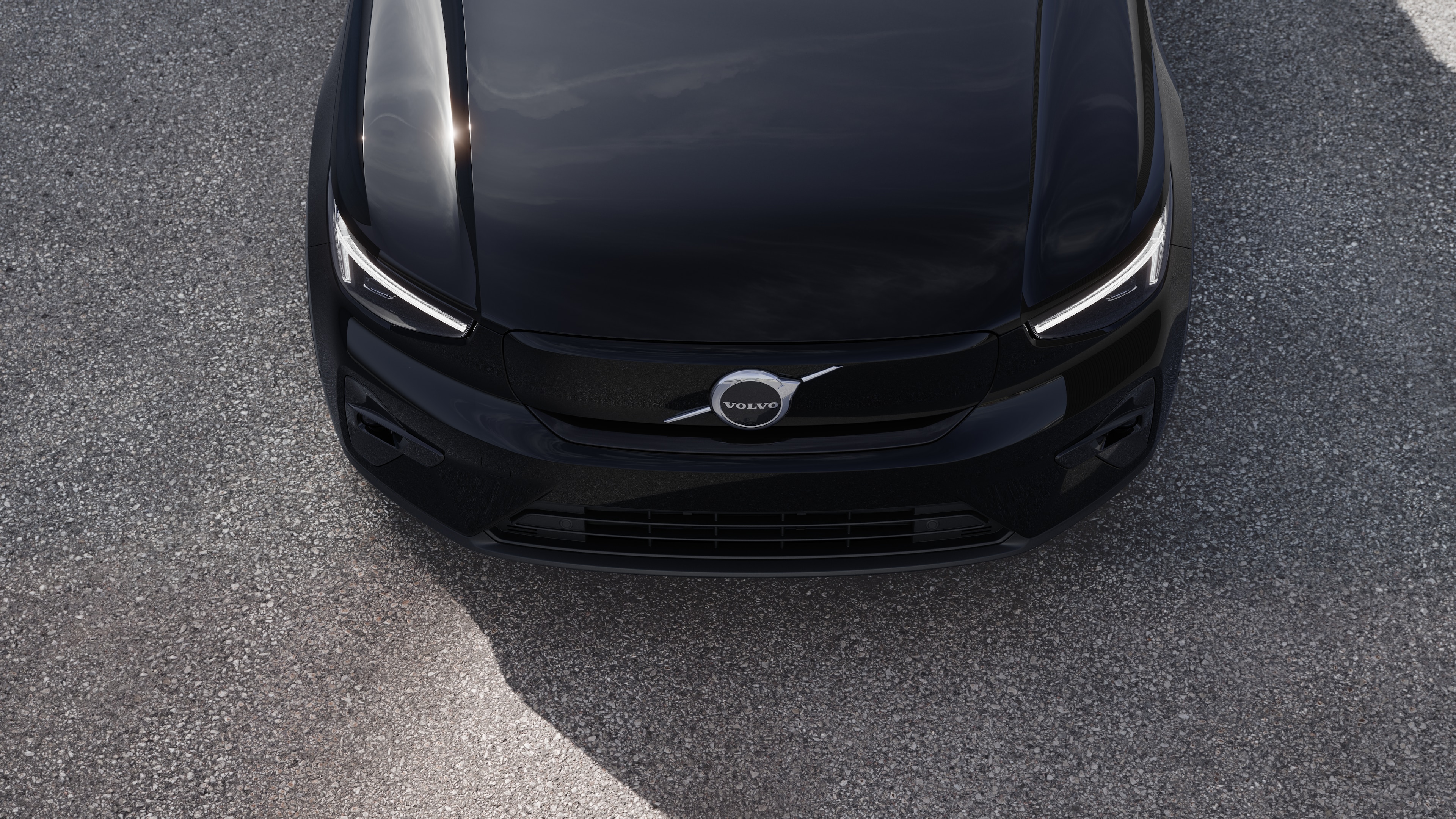 Volvo car exterior in three-quarter view on an urban street background, showing one side, roof, and part of the front.