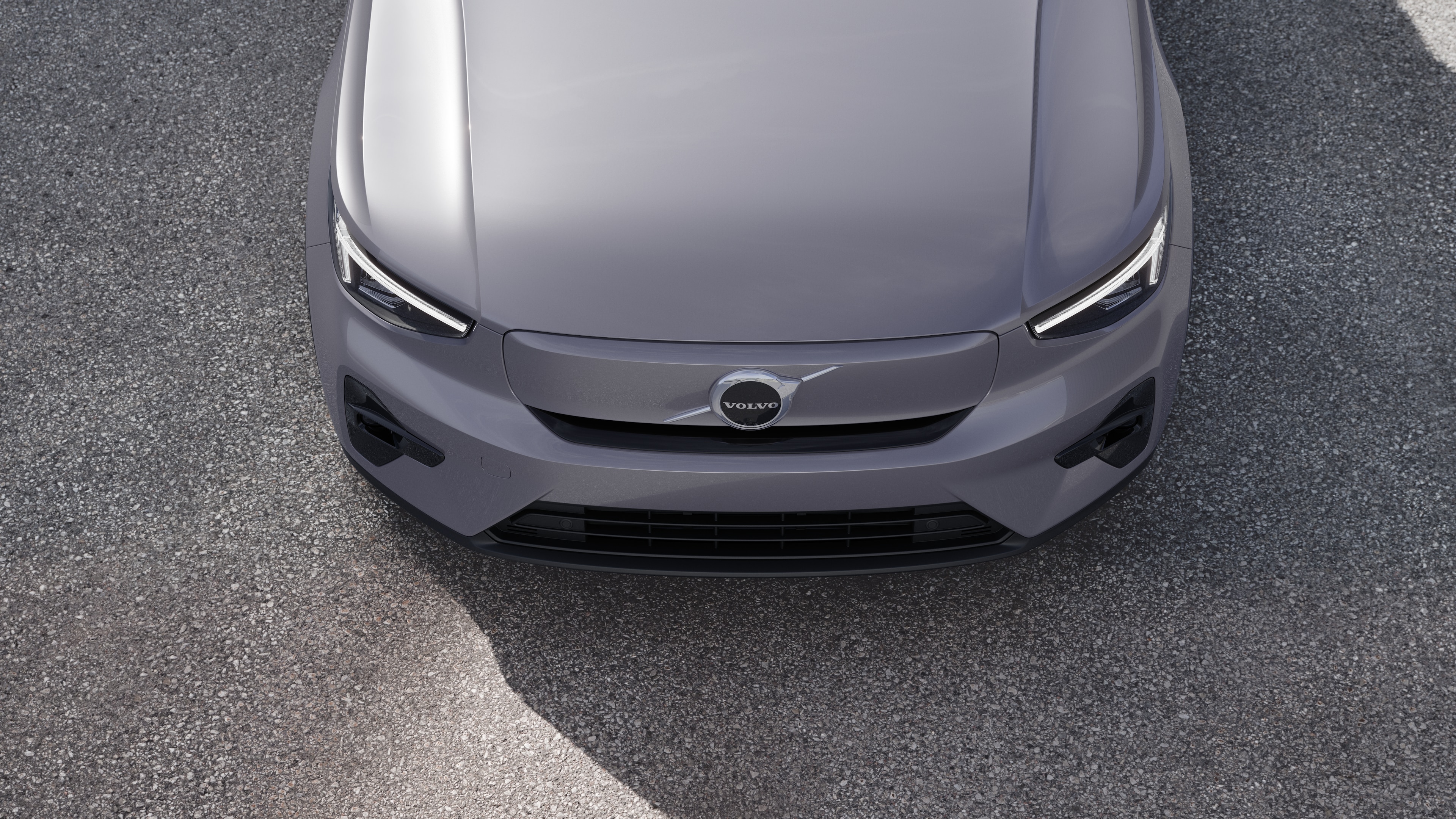 Volvo car exterior in three-quarter view on an urban street background, showing one side, roof, and part of the front.