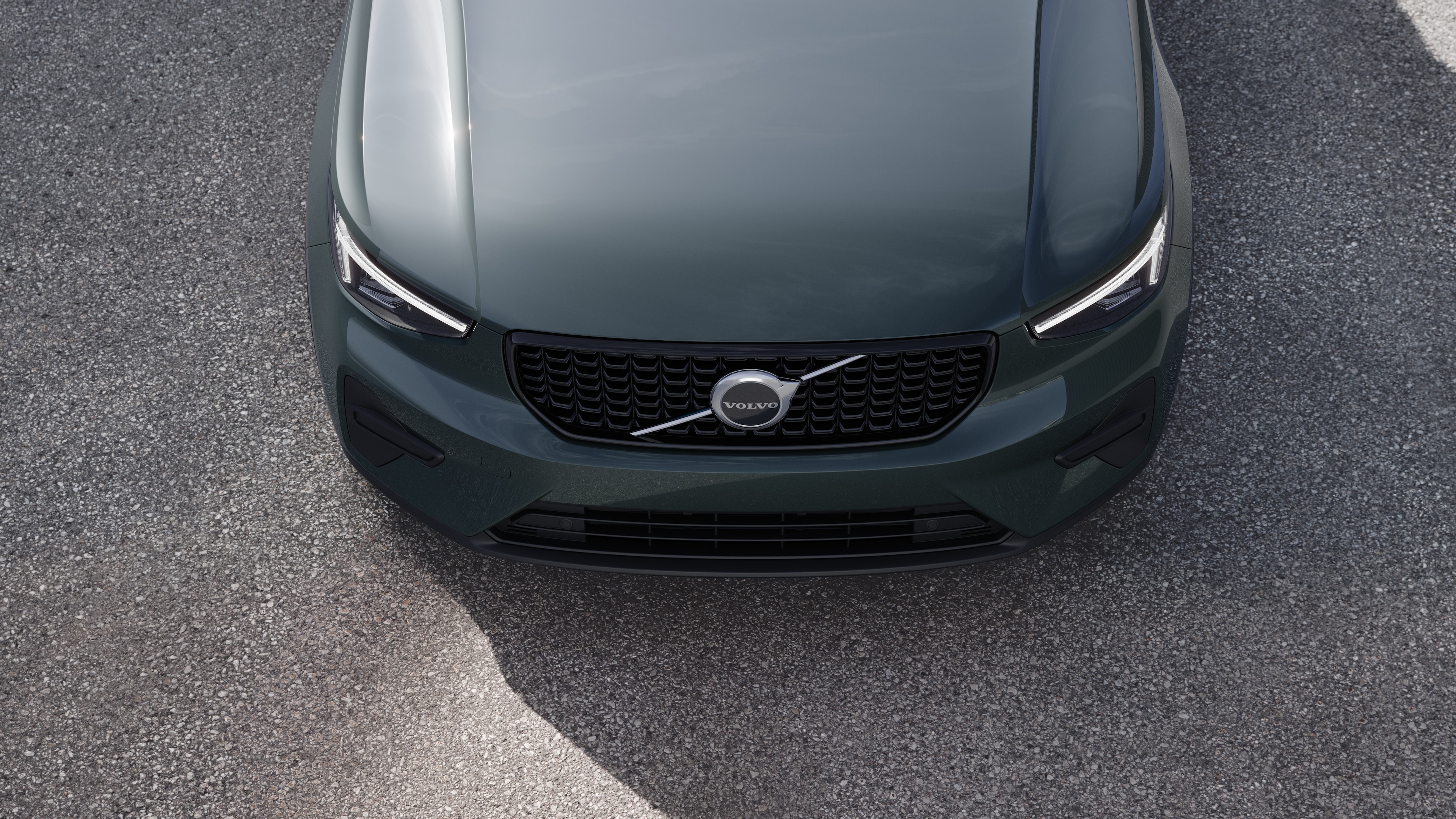 Volvo car exterior in three-quarter view on an urban street background, showing one side, roof, and part of the front.