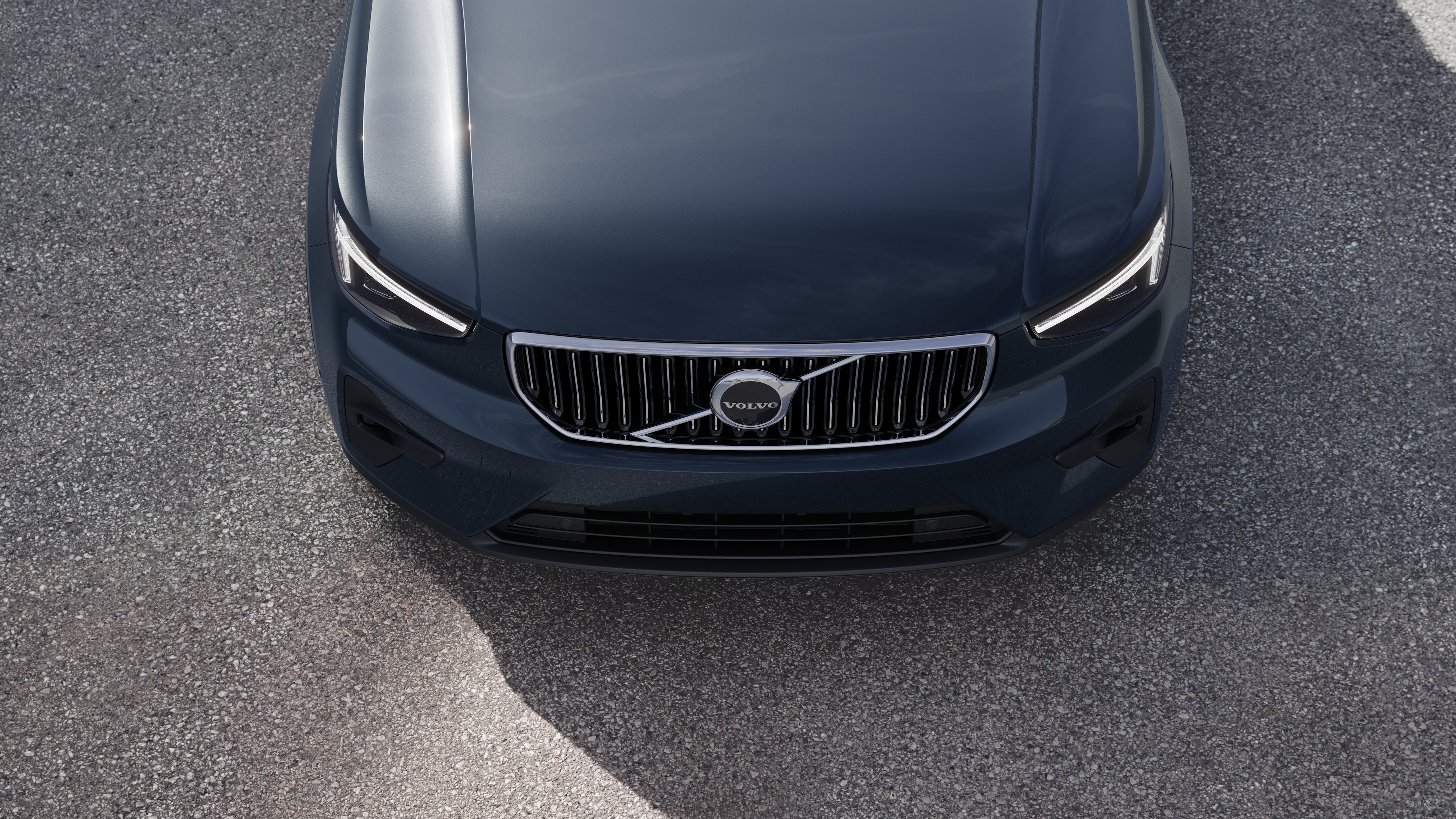 Volvo car exterior in three-quarter view on an urban street background, showing one side, roof, and part of the front.