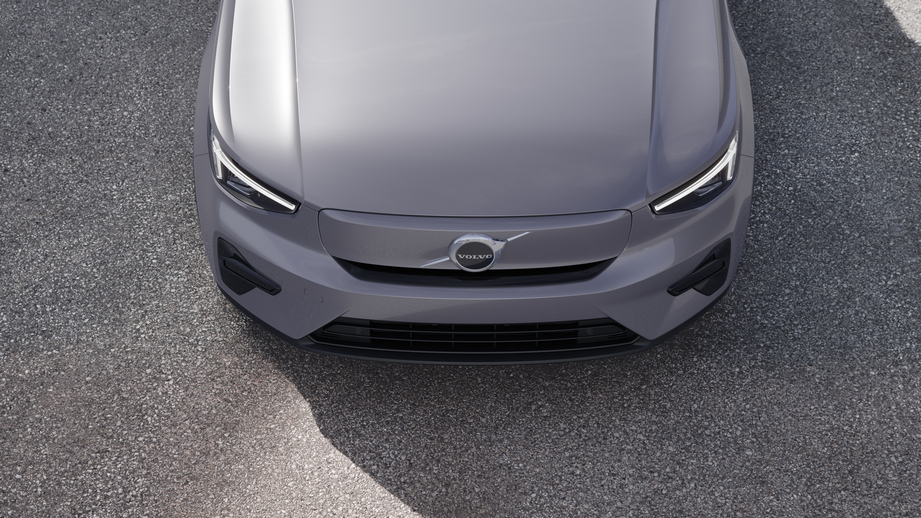 "Volvo" automobilio išorė su trijų ketvirčių vaizdu miesto gatvės fone, parodant vieną pusę, stogą ir dalį priekio.